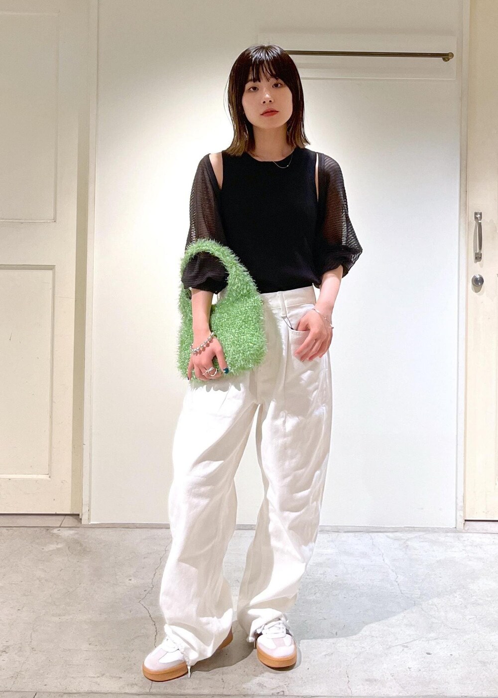 グレー系のカーディガン/ボレロ、グリーン系のハンドバッグ、ホワイト系のデニムパンツを着用したレディースの夏コーディネートの2枚目の写真