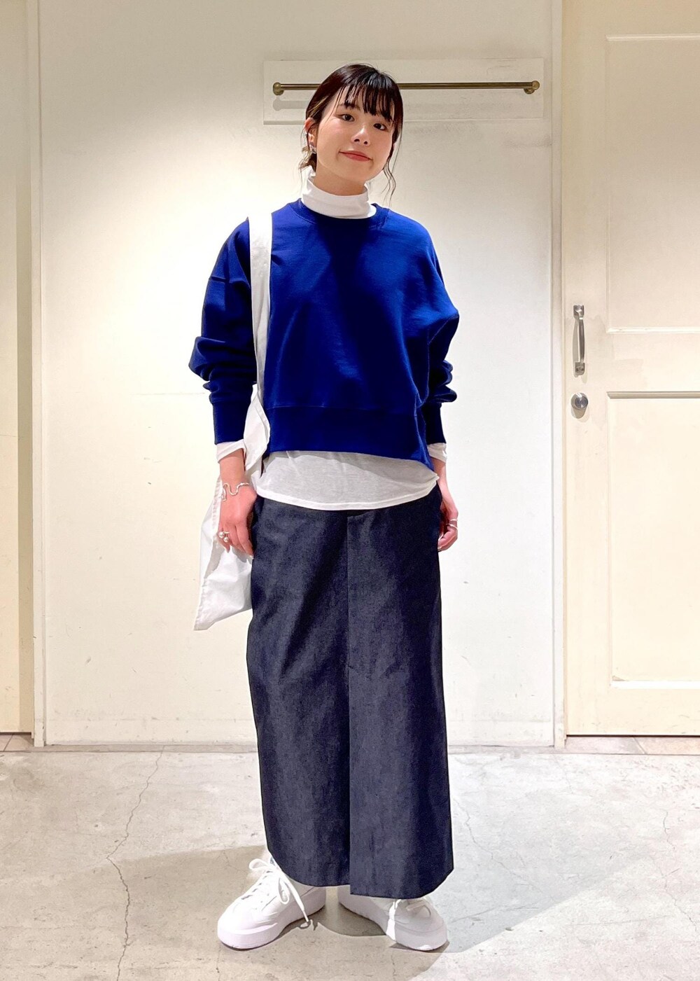 ホワイト系のTシャツ/カットソー、ホワイト系のトートバッグ、ブルー系のスウェットを着用したレディースの冬コーディネートの2枚目の写真