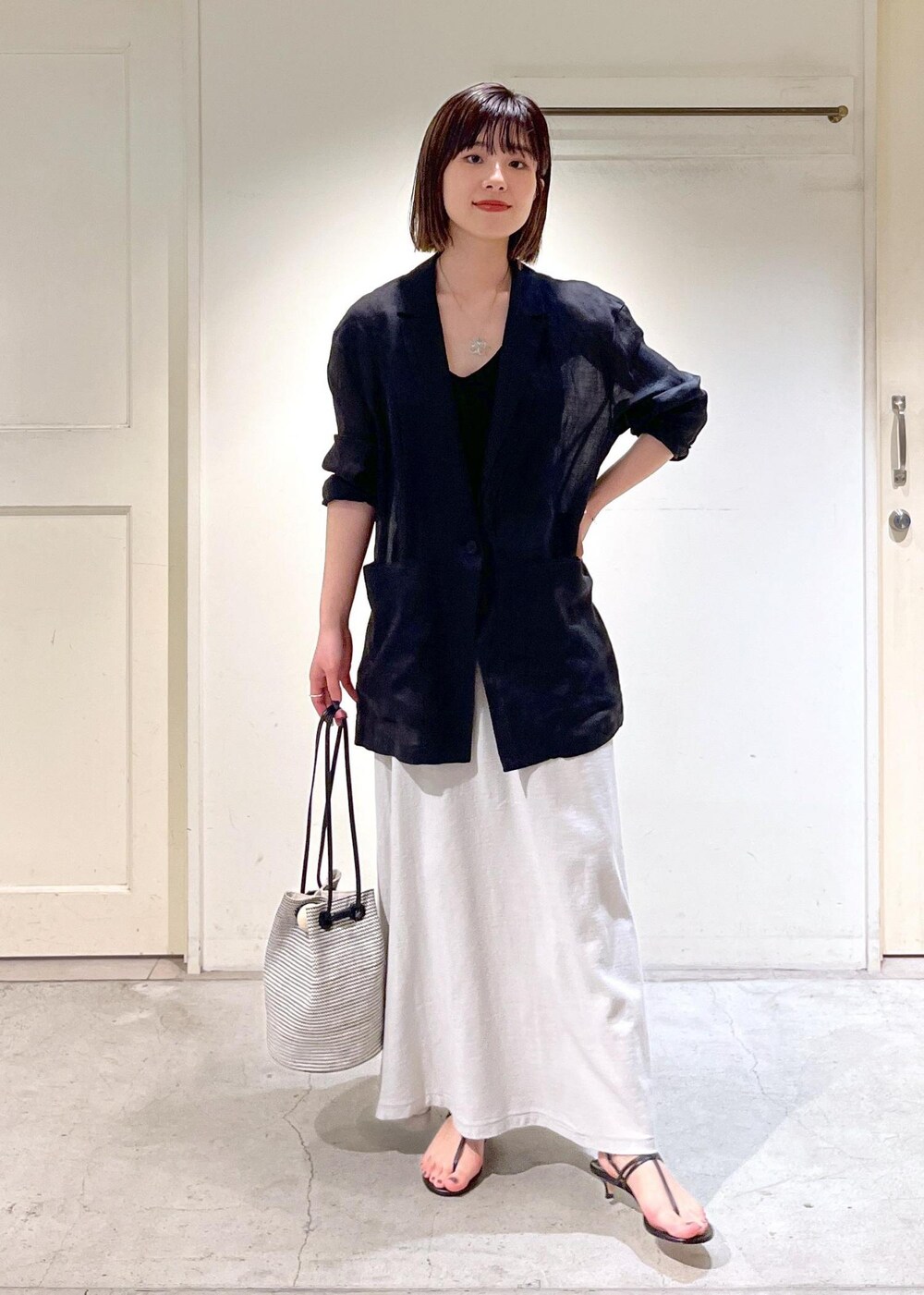 ブラック系のキャミソール、ブラック系のサンダル、ブラック系のショルダーバッグを着用したレディースの春コーディネートの4枚目の写真