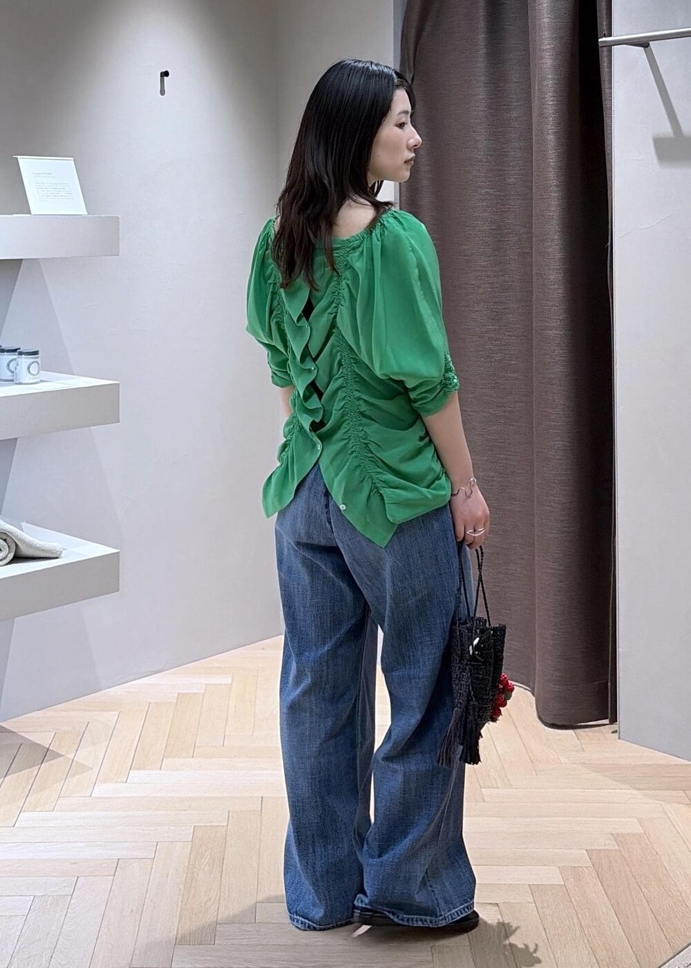 ブラック系のサンダル、ブルー系のデニムパンツ、ブラック系のハンドバッグを着用したレディースの春コーディネートの4枚目の写真