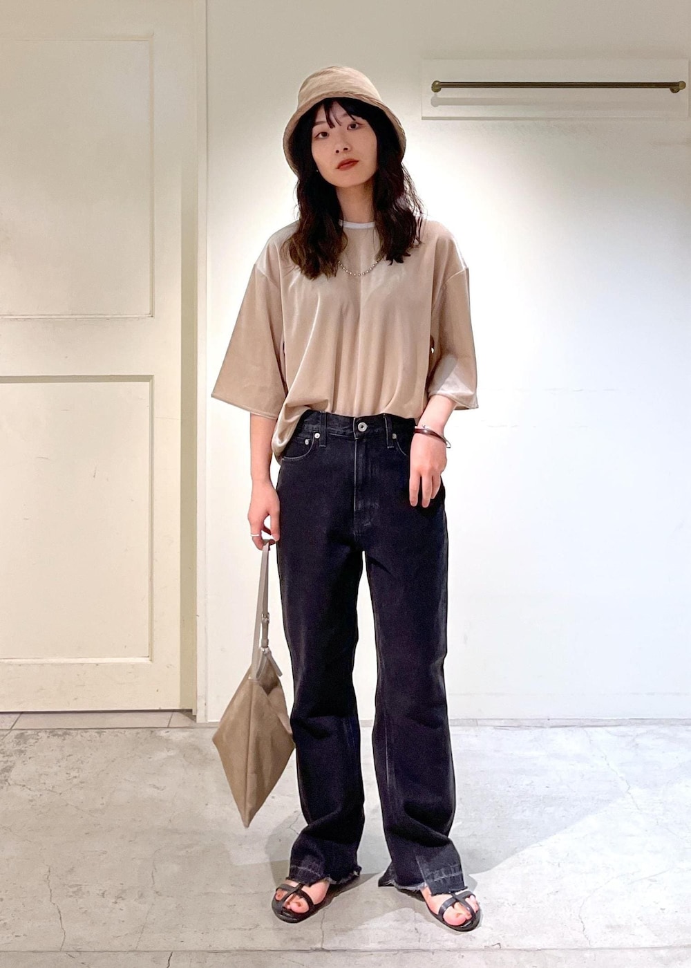 ブラック系のサンダル、グレー系のデニムパンツ、ベージュ系のTシャツ/カットソーを着用したレディースの夏コーディネートの6枚目の写真