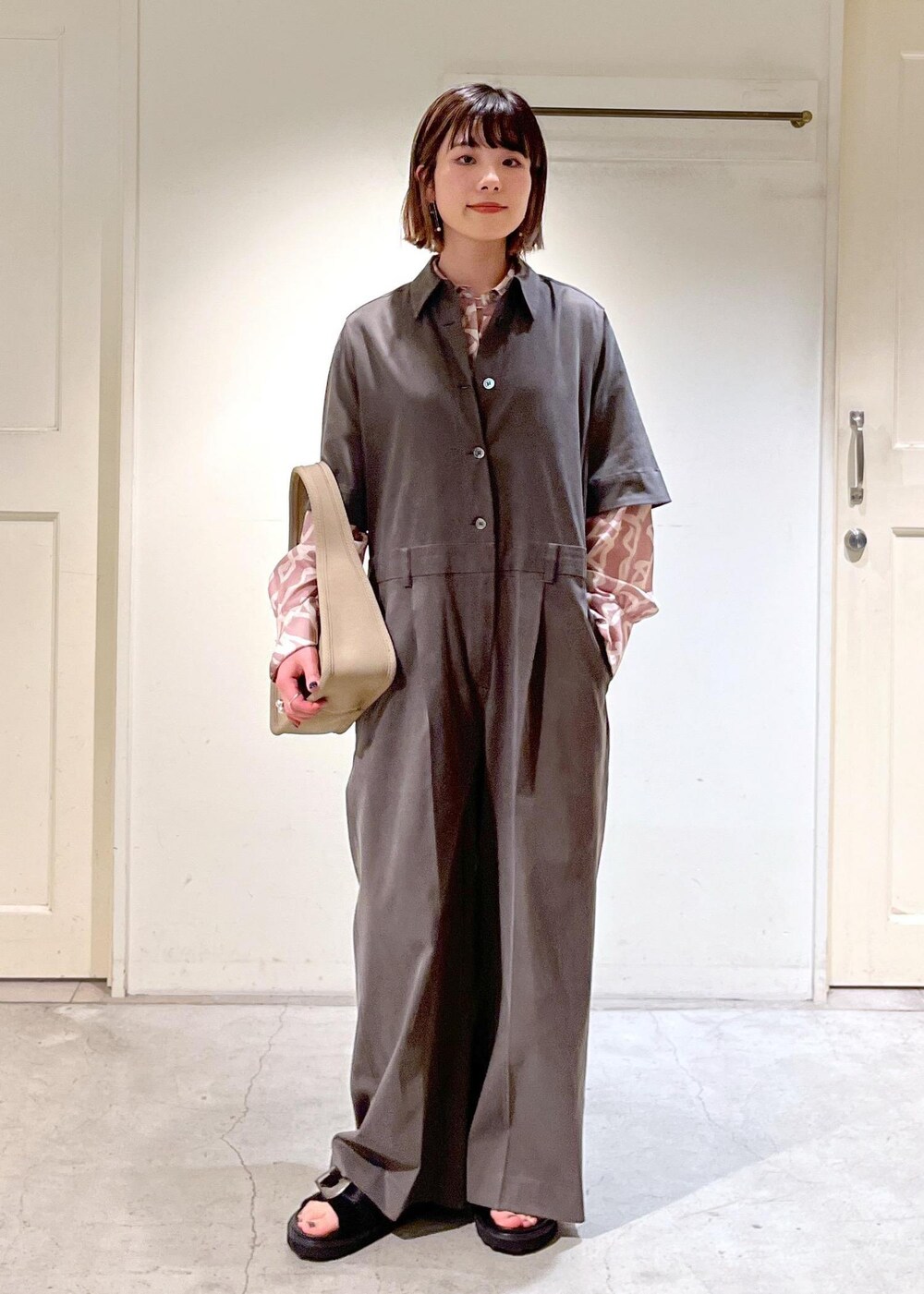 イエロー系のシャツ/ブラウス、ベージュ系のハンドバッグ、ブラック系のサンダルを着用したレディースの春コーディネートの2枚目の写真