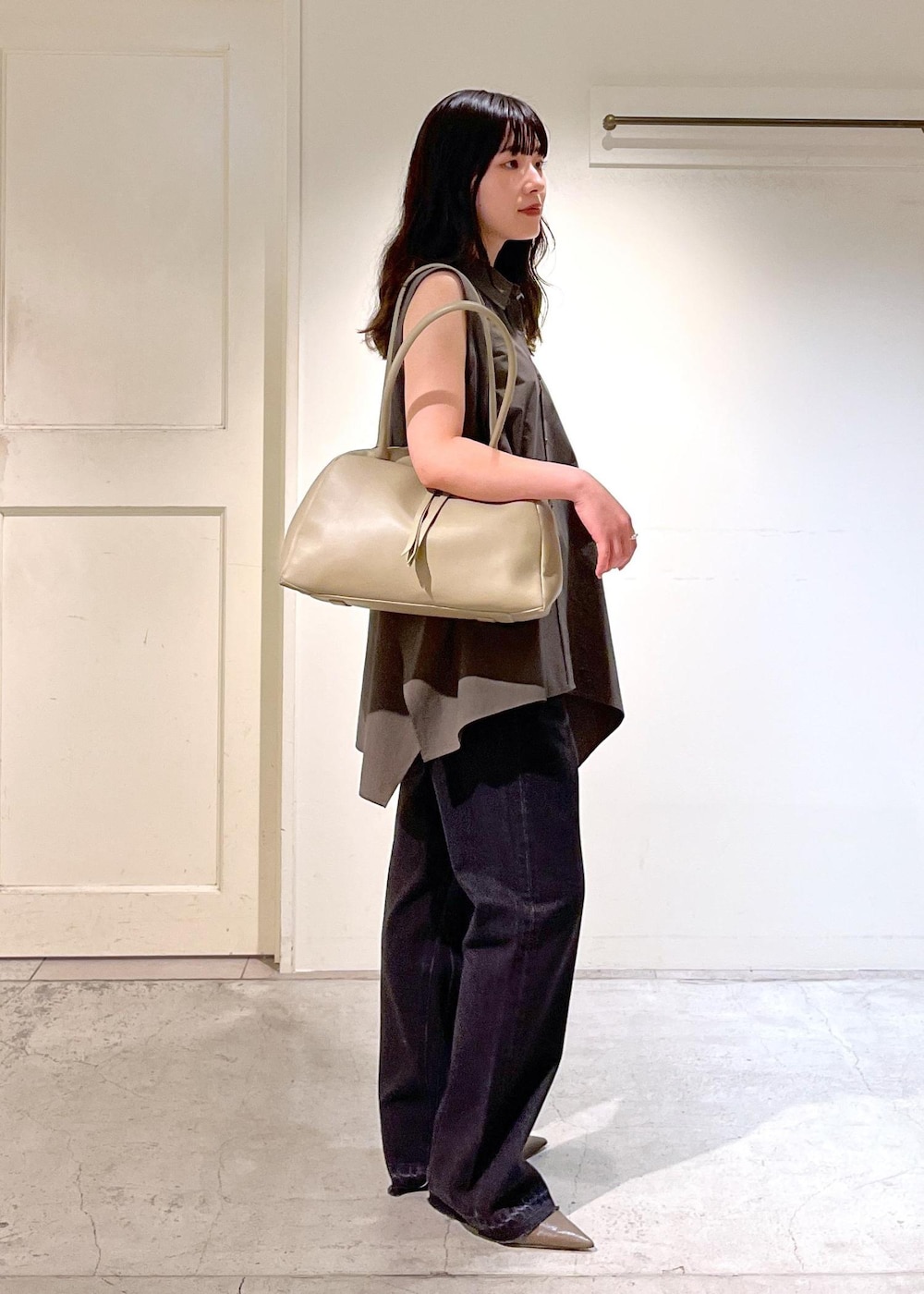 ベージュ系のボストンバッグ、グレー系のデニムパンツ、グレー系のシャツ/ブラウスを着用したレディースの夏コーディネートの3枚目の写真