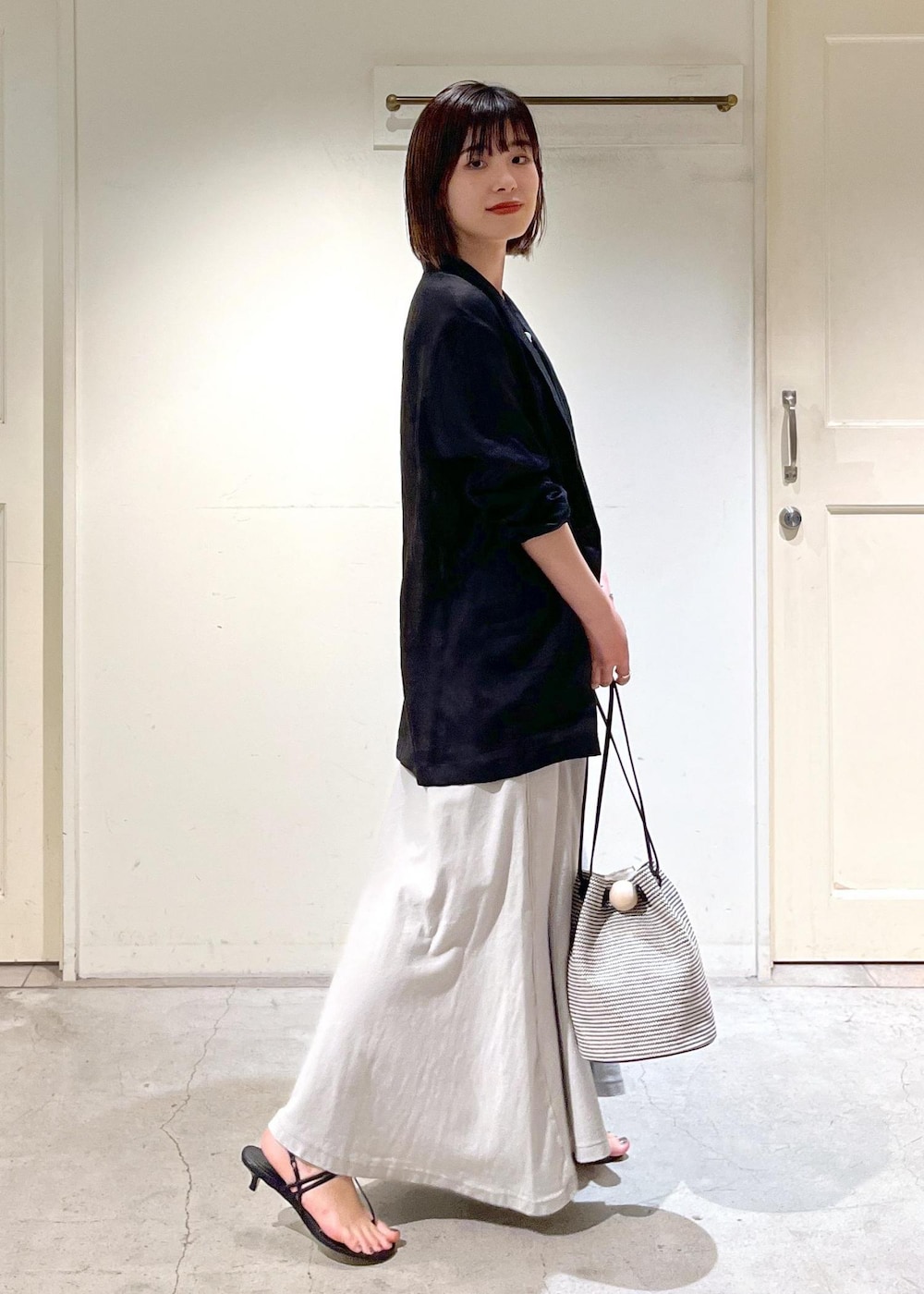 ブラック系のキャミソール、ブラック系のサンダル、ブラック系のショルダーバッグを着用したレディースの春コーディネートの7枚目の写真