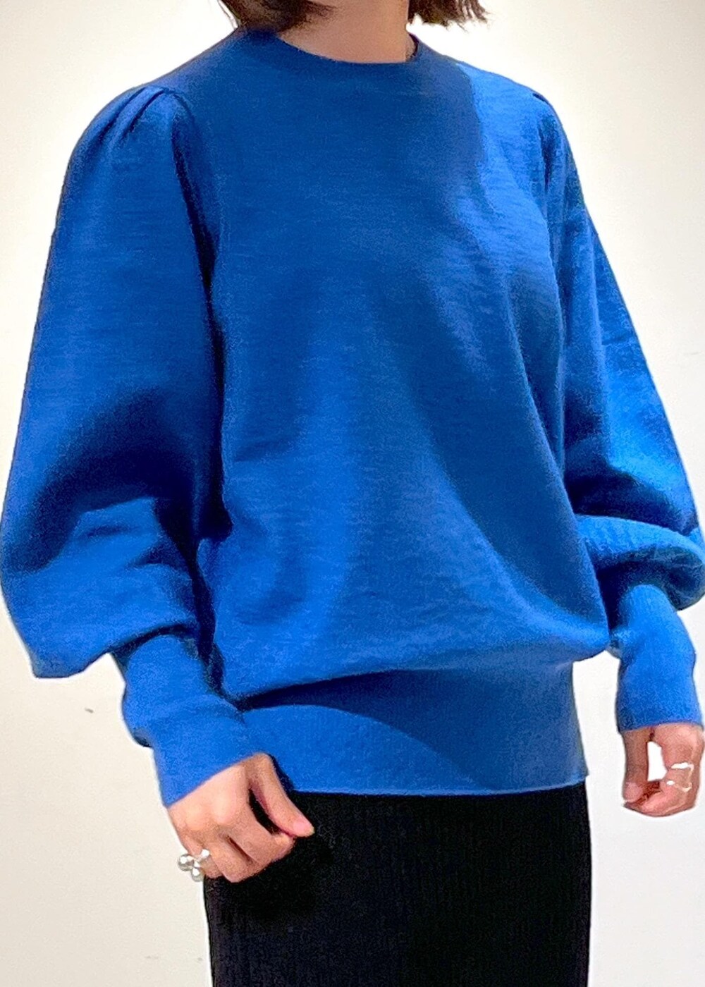 ブラック系のブーツ、ブラック系のスカート、ブルー系のニット/セーターを着用したレディースの秋コーディネートの7枚目の写真