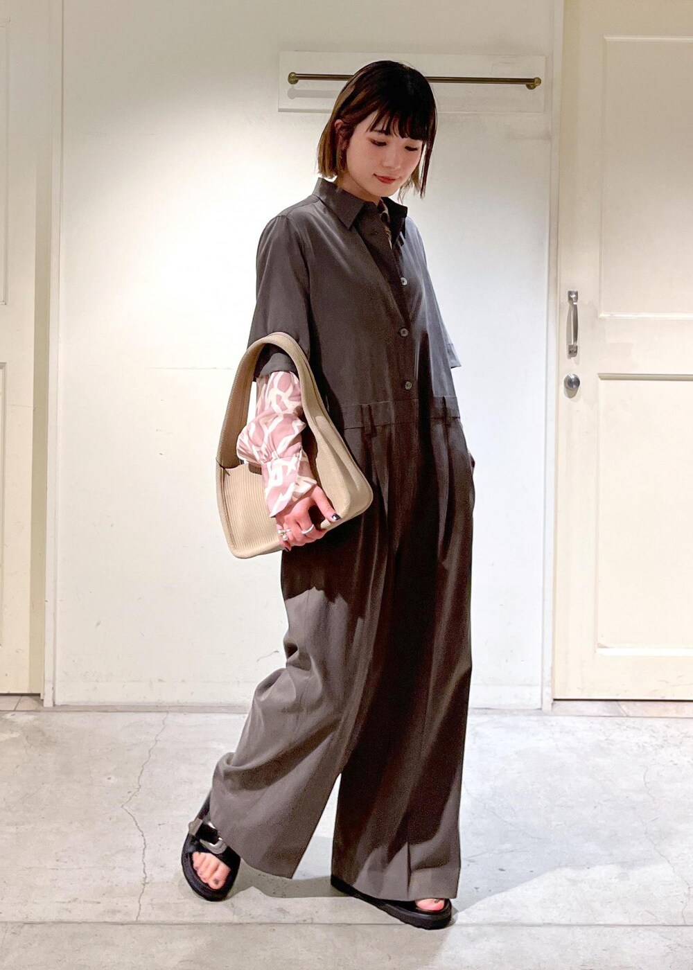 イエロー系のシャツ/ブラウス、ベージュ系のハンドバッグ、ブラック系のサンダルを着用したレディースの春コーディネートの5枚目の写真