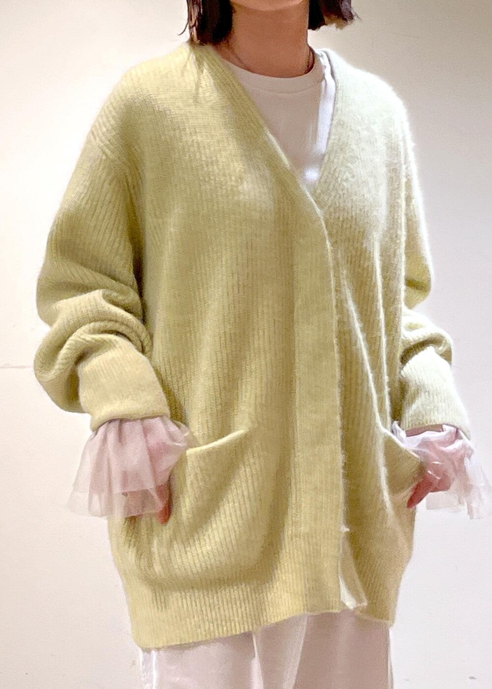 イエロー系のカーディガン/ボレロ、ブラウン系のブーツ、ホワイト系のその他パンツを着用したレディースの秋コーディネートの7枚目の写真