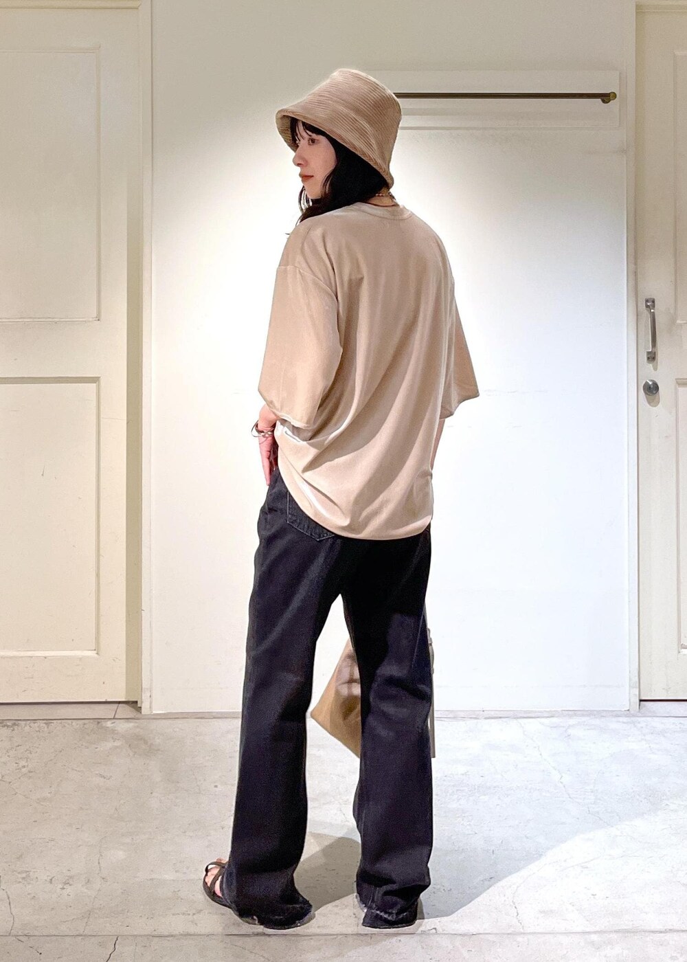 ブラック系のサンダル、グレー系のデニムパンツ、ベージュ系のTシャツ/カットソーを着用したレディースの夏コーディネートの4枚目の写真