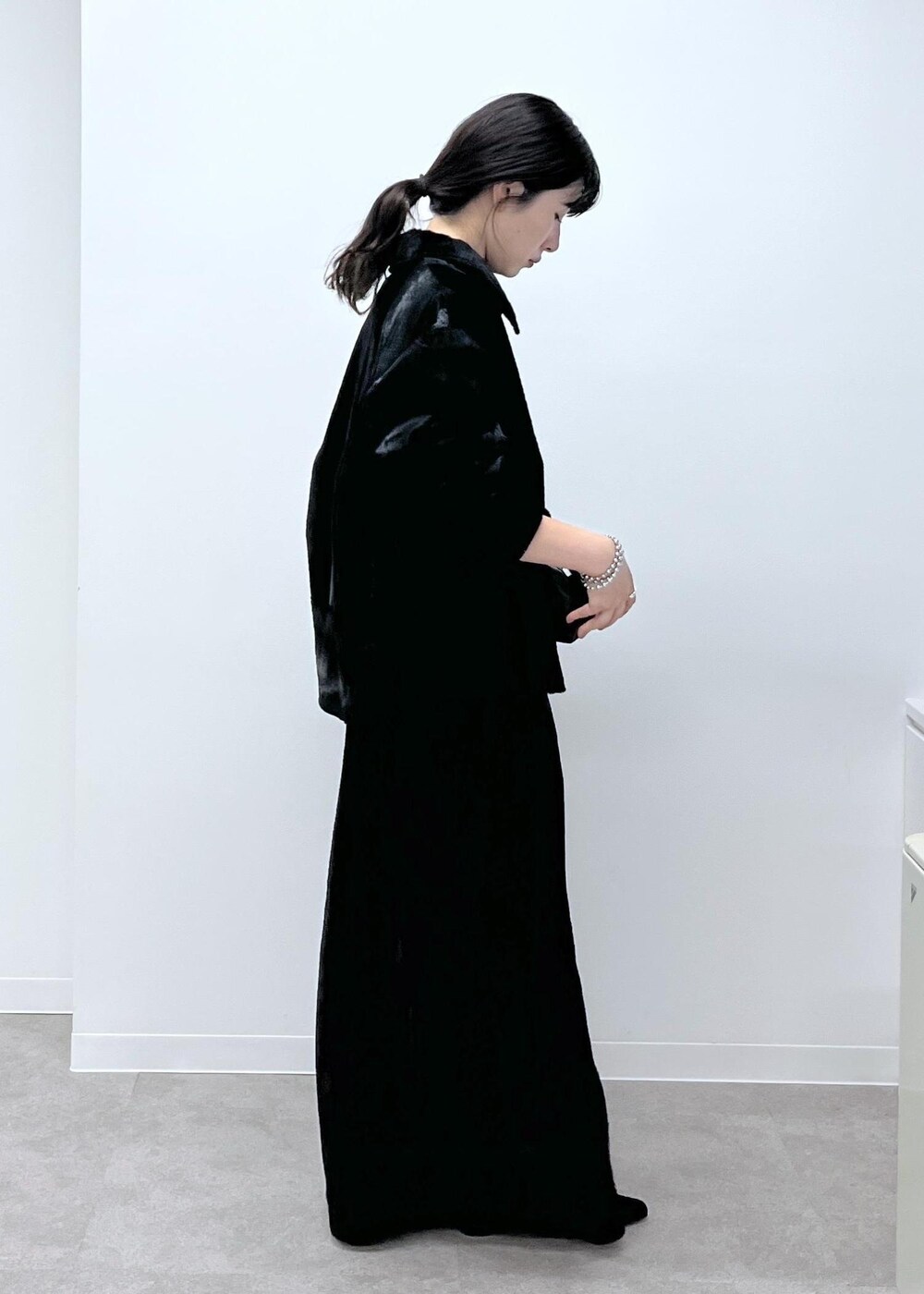 ブラック系のスカート、ブラック系のブルゾン、ブラック系のサンダルを着用したレディースの秋コーディネートの4枚目の写真