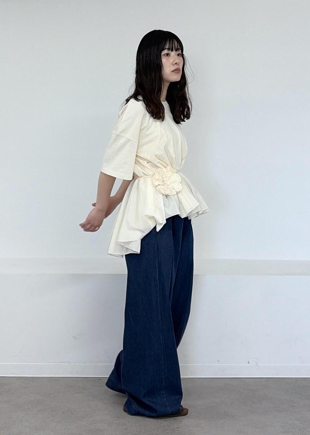 ベージュ系のショルダーバッグ、ブルー系のデニムパンツ、ブラウン系のサンダルを着用したレディースの冬コーディネートの8枚目の写真