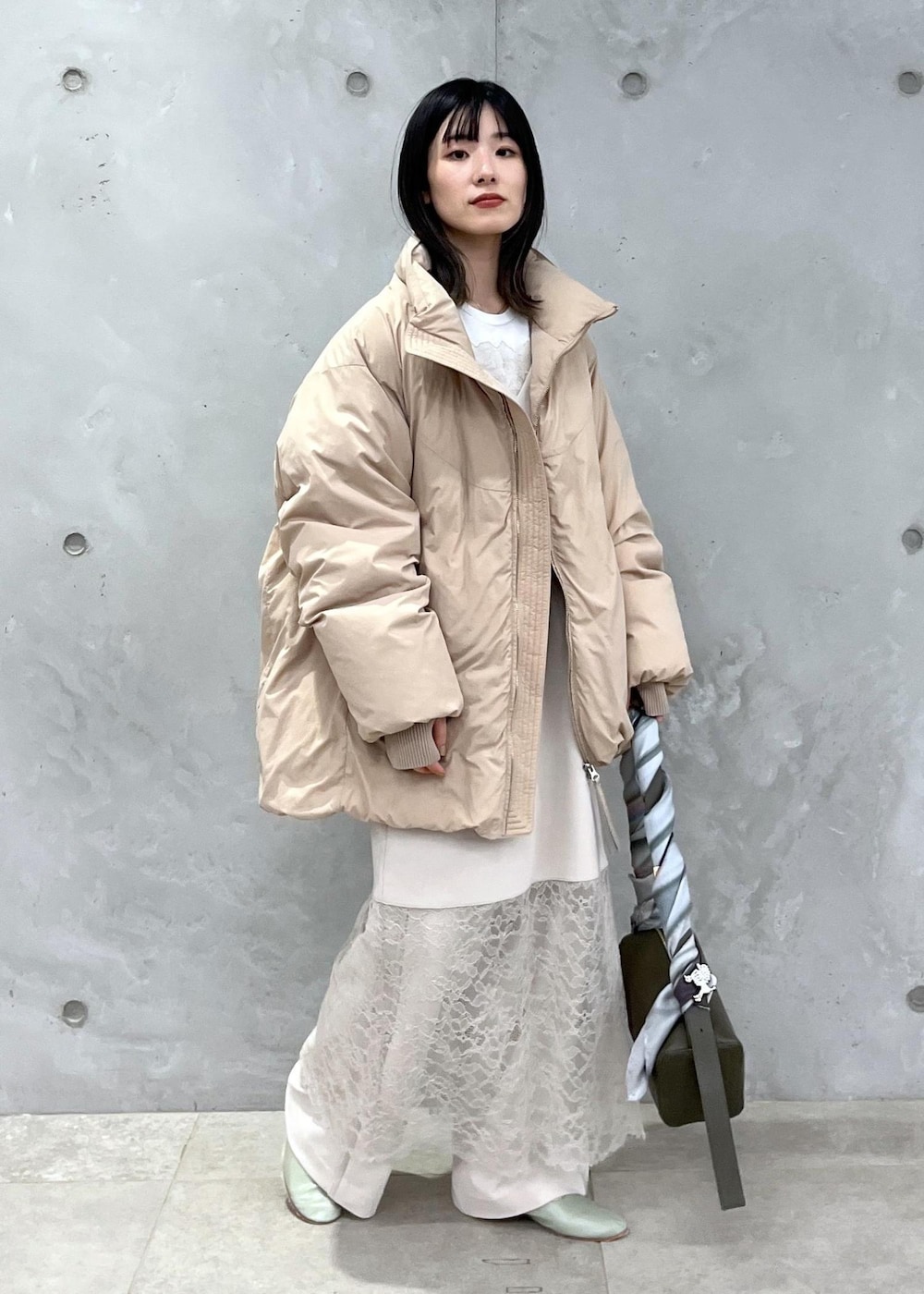 ベージュ系のダウンジャケット/コート、ホワイト系のその他パンツ、ホワイト系のワンピースを着用したレディースの冬コーディネートの5枚目の写真