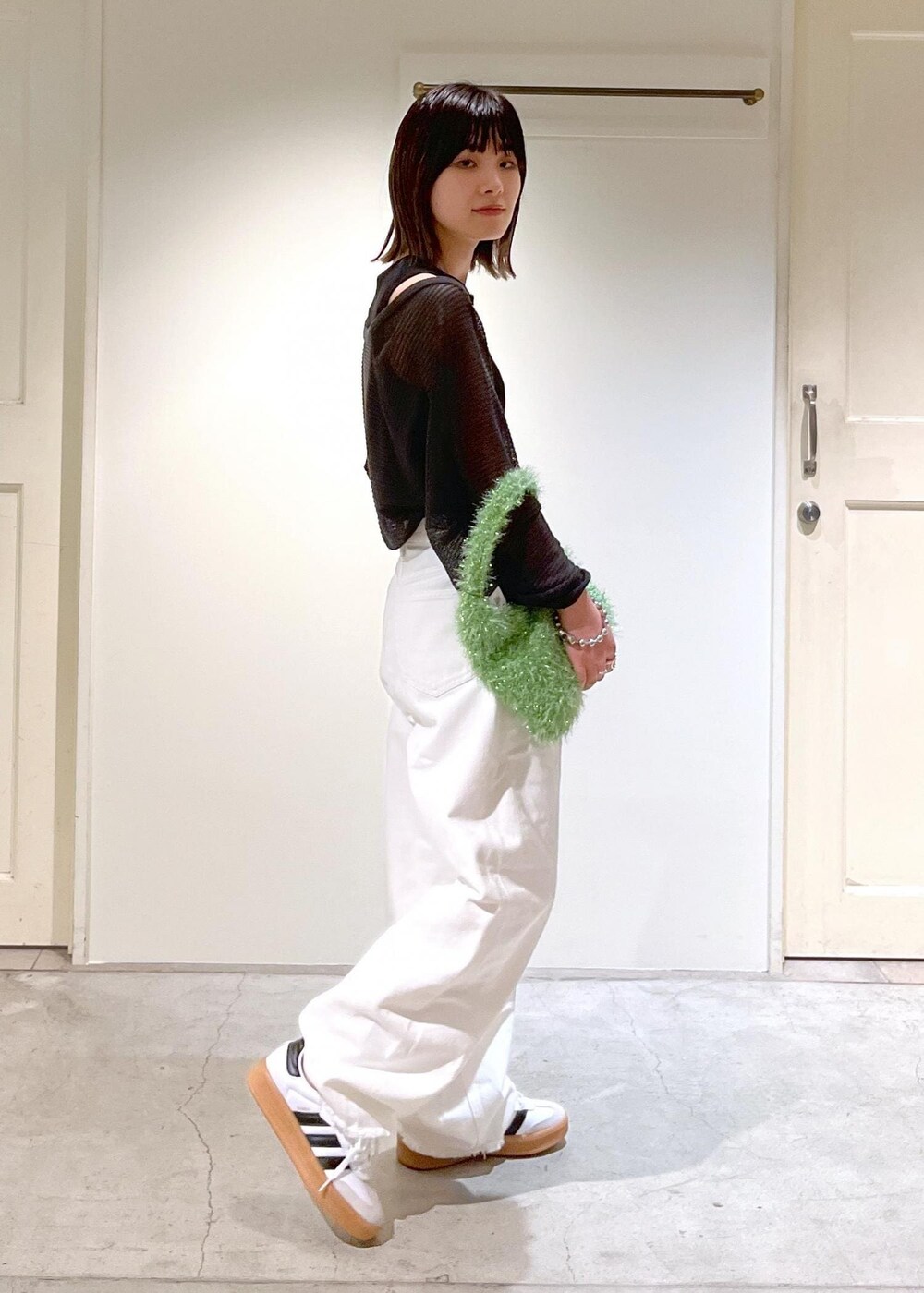 グレー系のカーディガン/ボレロ、グリーン系のハンドバッグ、ホワイト系のデニムパンツを着用したレディースの夏コーディネートの3枚目の写真