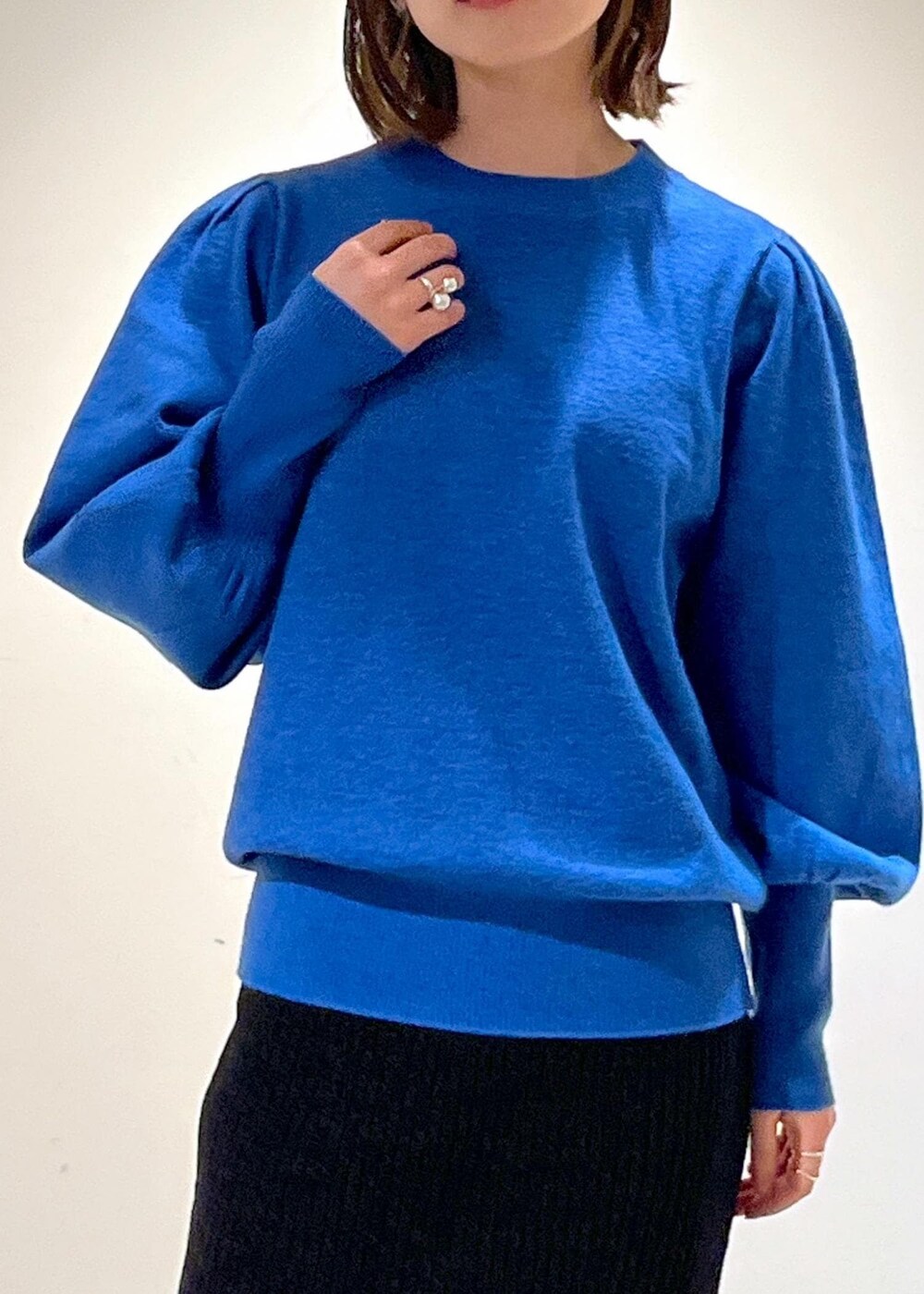 ブラック系のブーツ、ブラック系のスカート、ブルー系のニット/セーターを着用したレディースの秋コーディネートの6枚目の写真