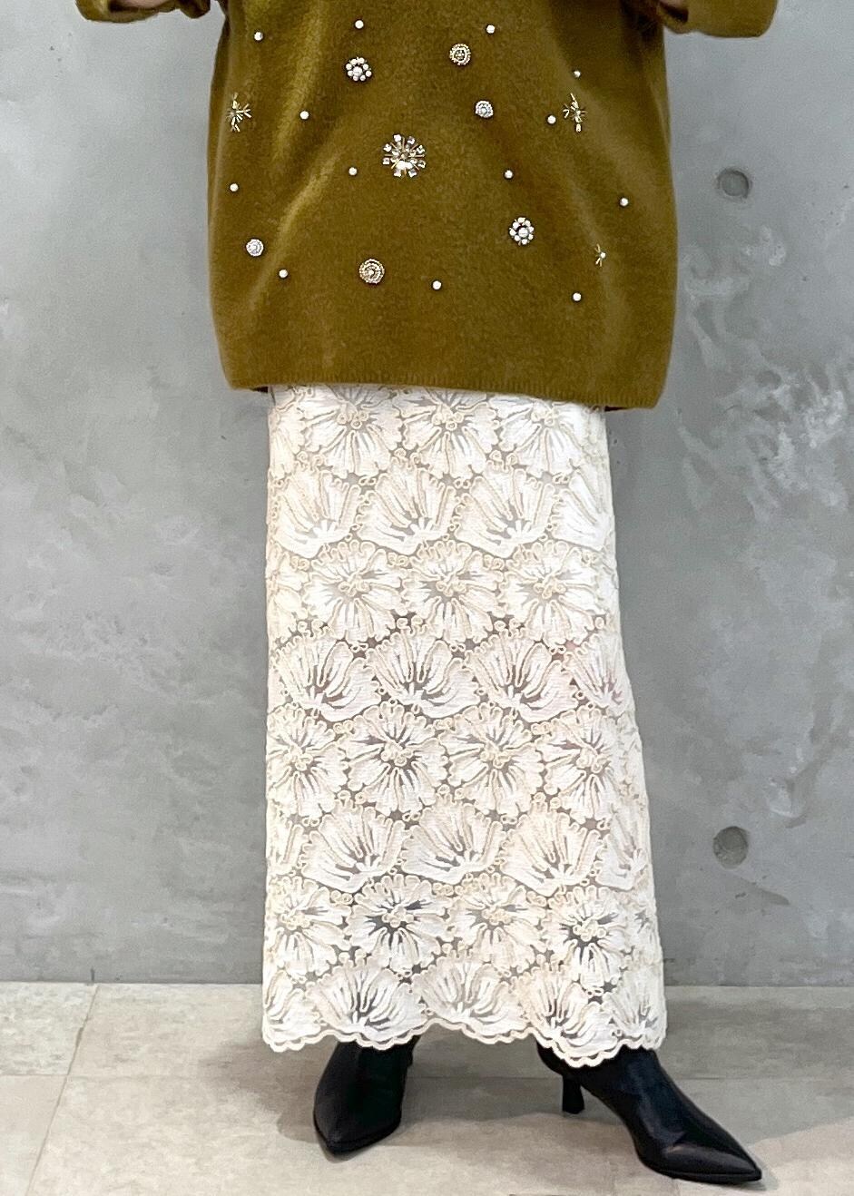 ブラック系のショルダーバッグ、ベージュ系のスカート、イエロー系のニット/セーターを着用したレディースの秋コーディネートの9枚目の写真