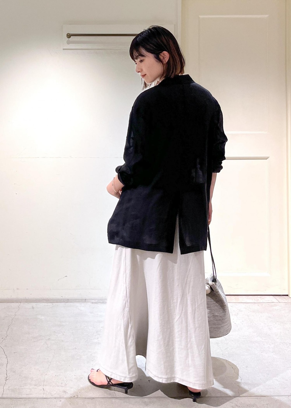 ブラック系のキャミソール、ブラック系のサンダル、ブラック系のショルダーバッグを着用したレディースの春コーディネートの9枚目の写真