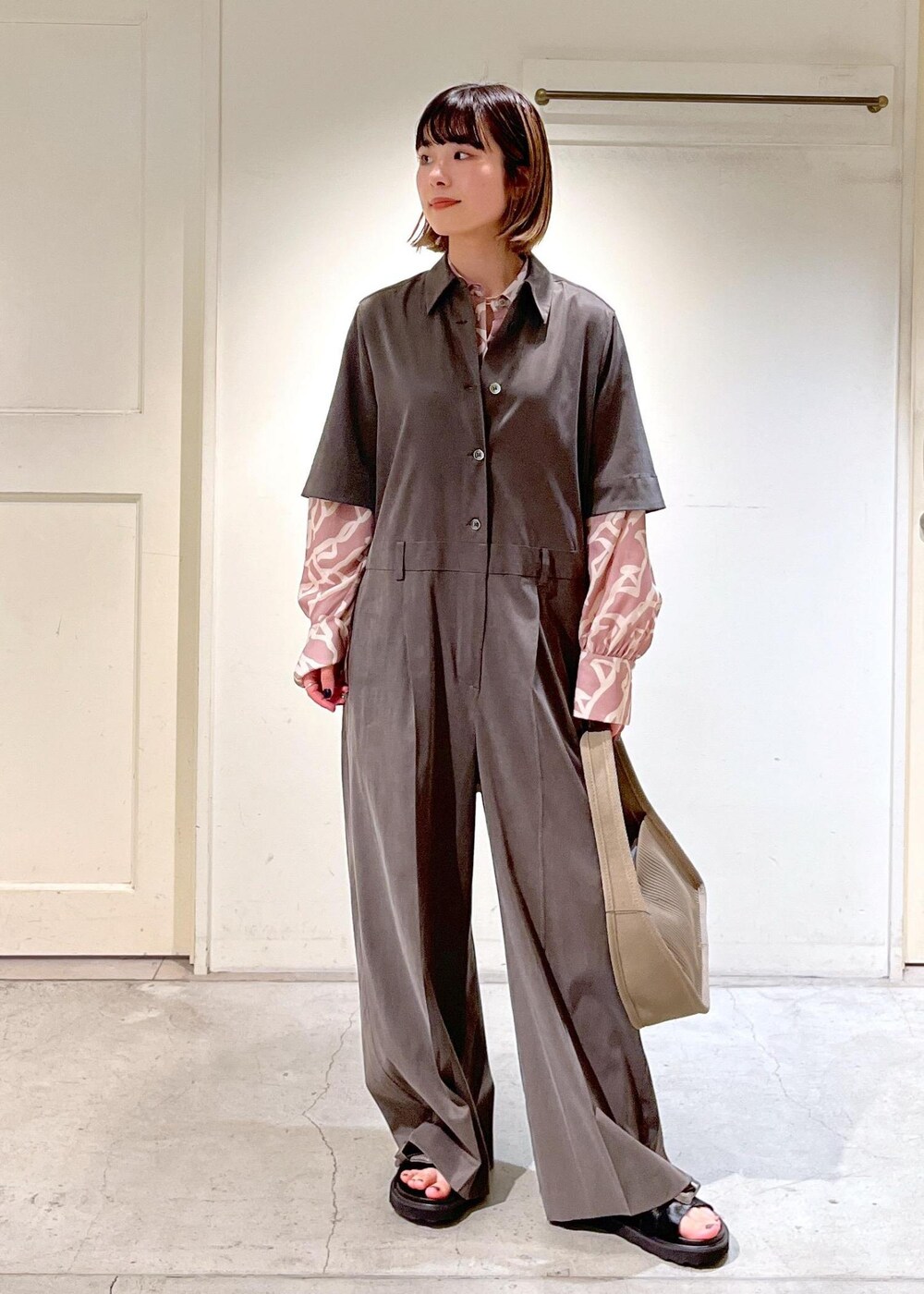 イエロー系のシャツ/ブラウス、ベージュ系のハンドバッグ、ブラック系のサンダルを着用したレディースの春コーディネートの4枚目の写真