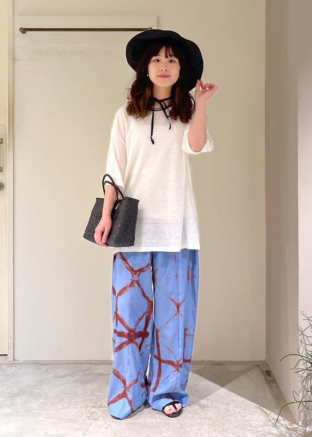 ブラック系のかごバッグ、ブラック系のサンダル、ブルー系のその他パンツを着用したレディースの春コーディネートの3枚目の写真