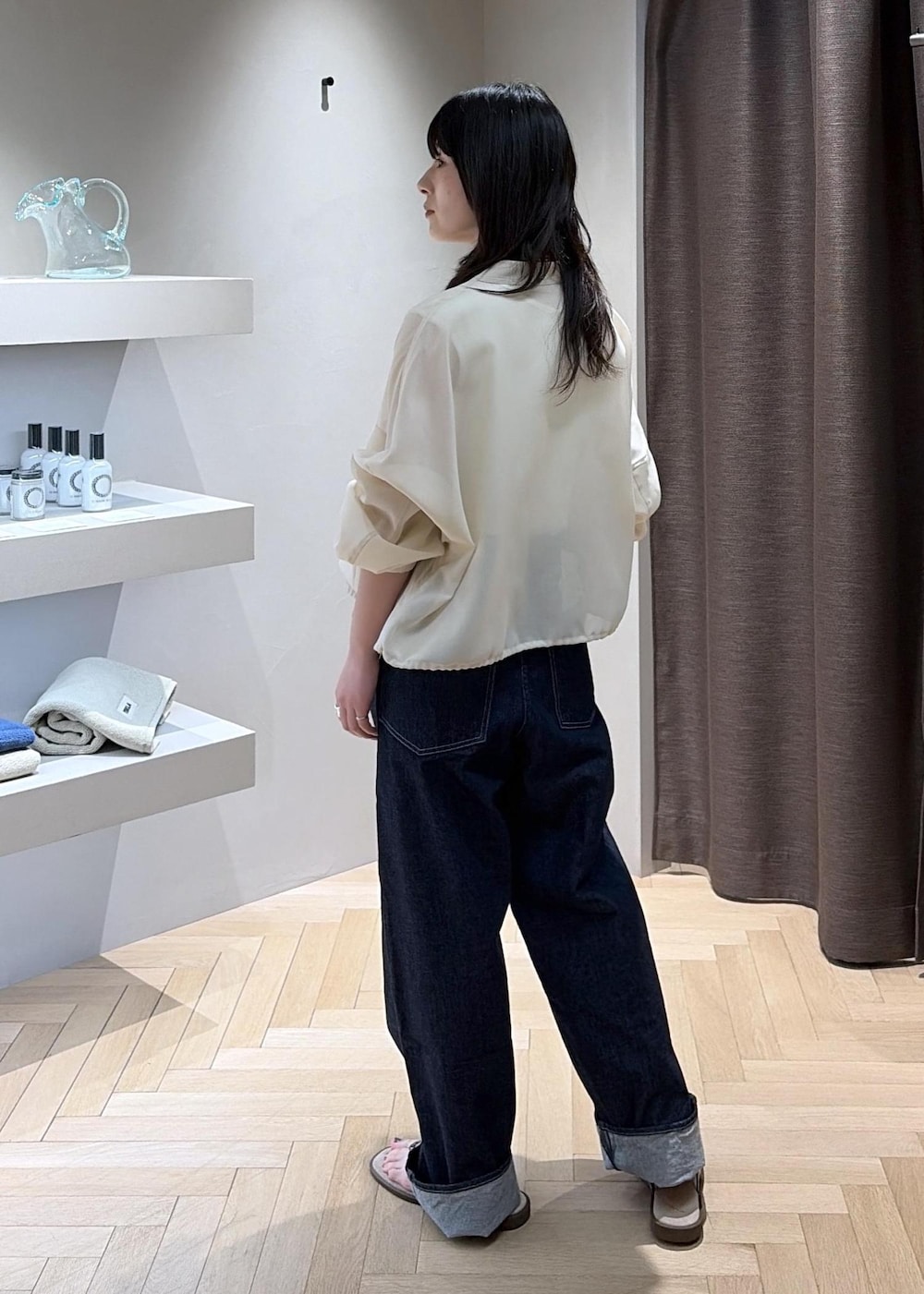 ベージュ系のサンダル、ブラウン系のハンドバッグ、ブルー系のデニムパンツを着用したレディースの夏コーディネートの4枚目の写真