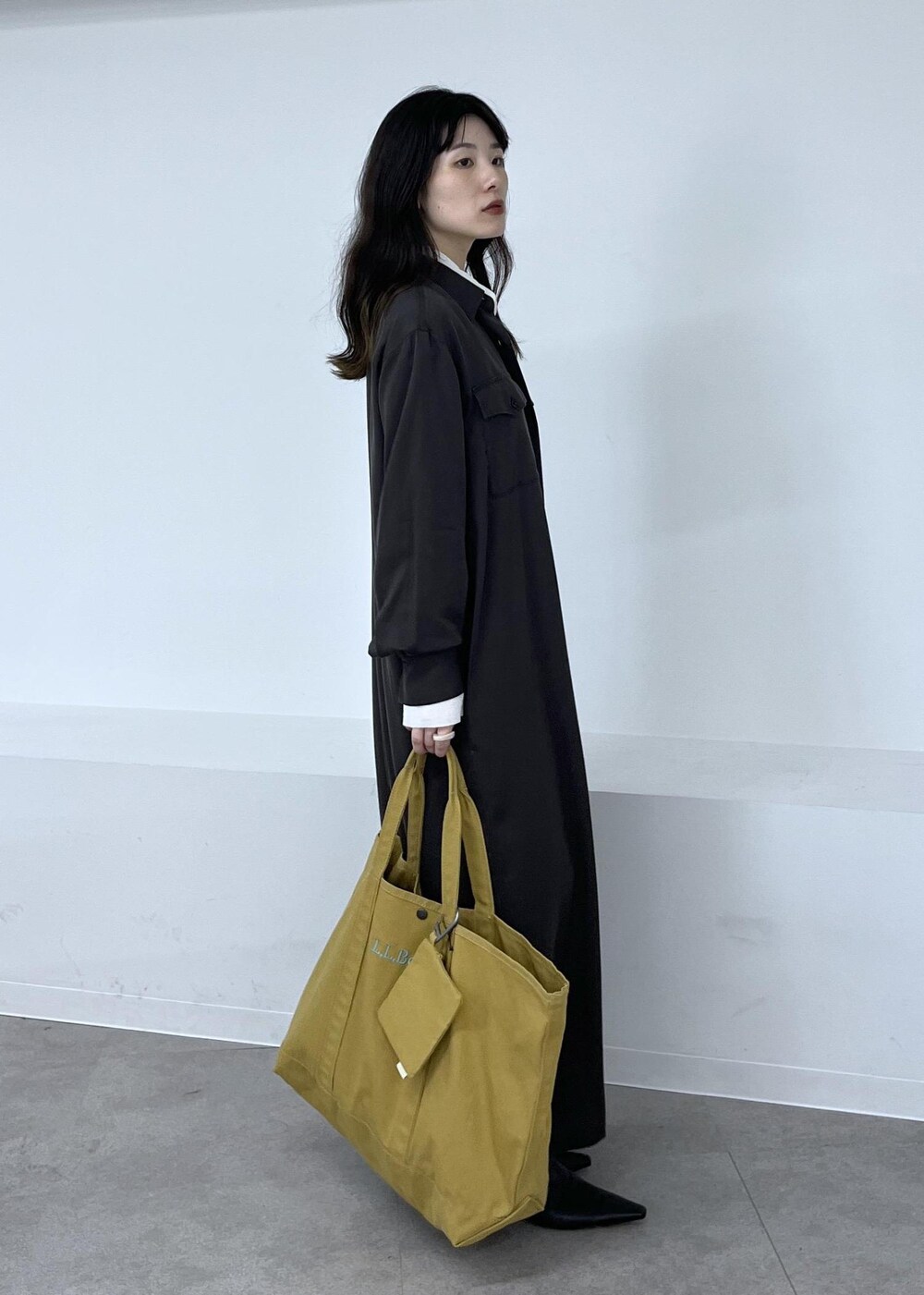 ホワイト系のシャツ/ブラウス、グレー系のワンピース、ブラック系のブーツを着用したレディースの秋コーディネートの4枚目の写真