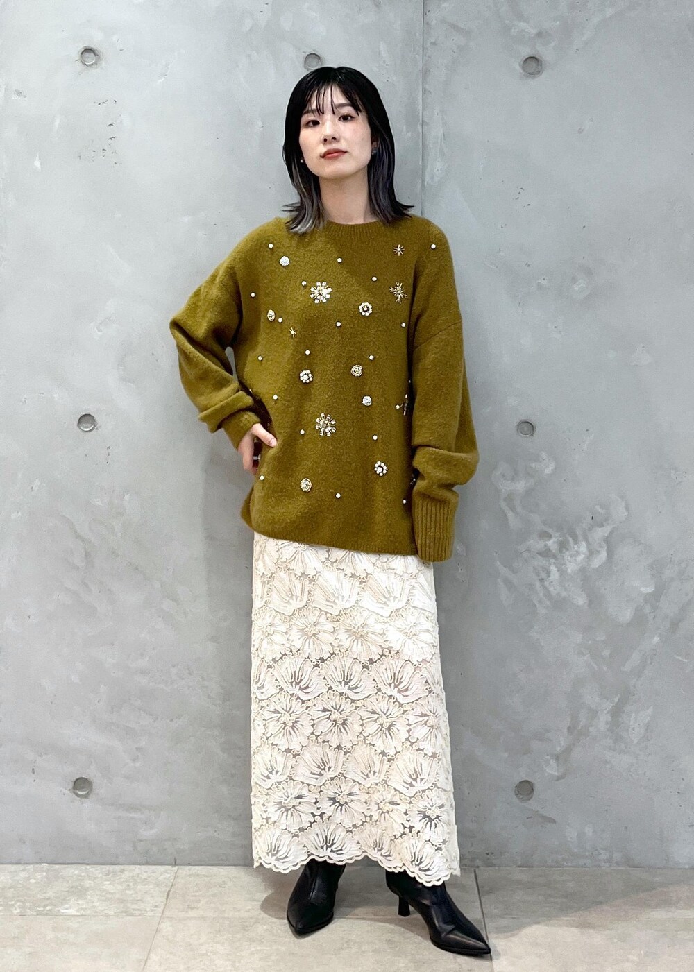 ブラック系のショルダーバッグ、ベージュ系のスカート、イエロー系のニット/セーターを着用したレディースの秋コーディネートの7枚目の写真