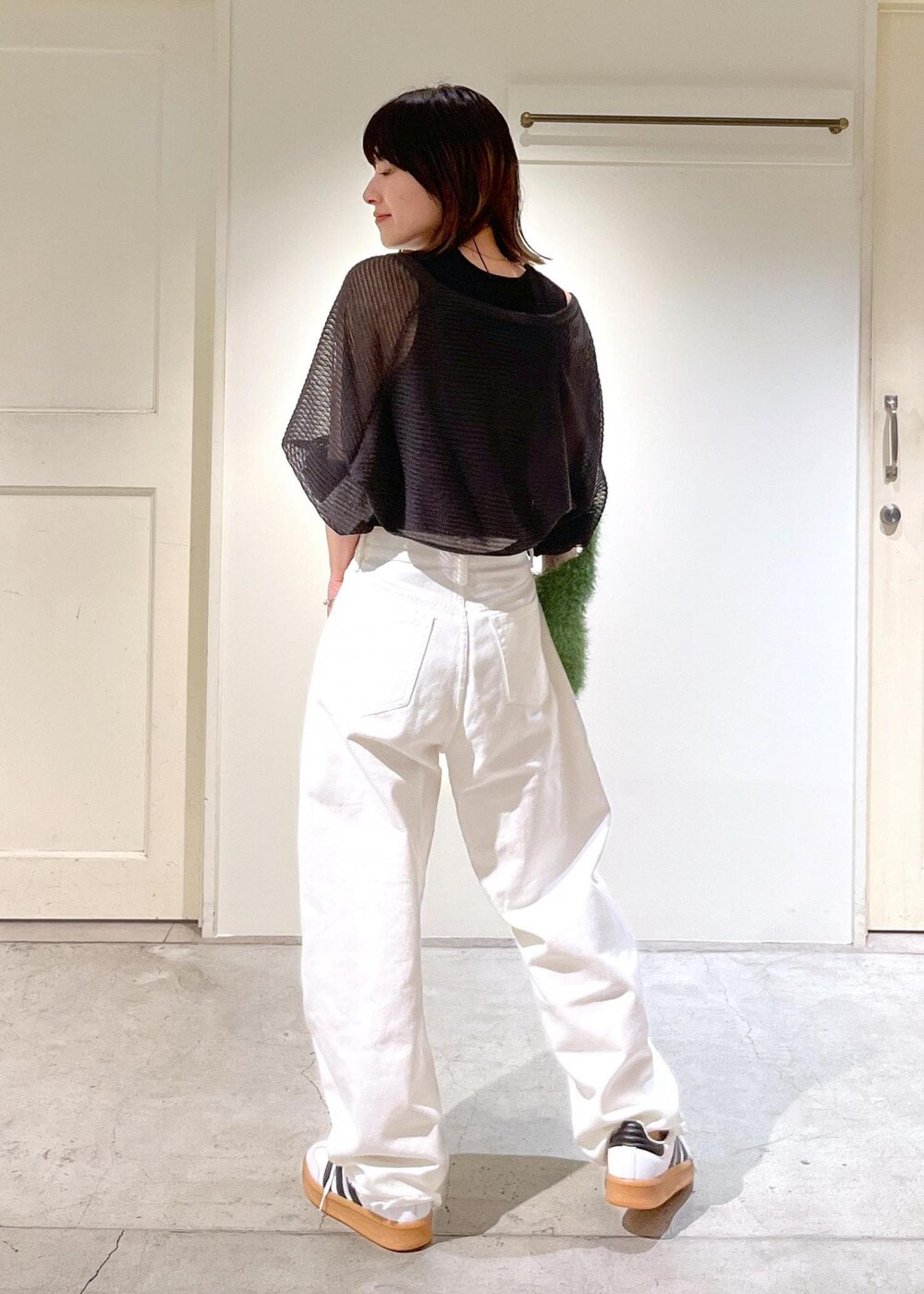 グレー系のカーディガン/ボレロ、グリーン系のハンドバッグ、ホワイト系のデニムパンツを着用したレディースの夏コーディネートの4枚目の写真