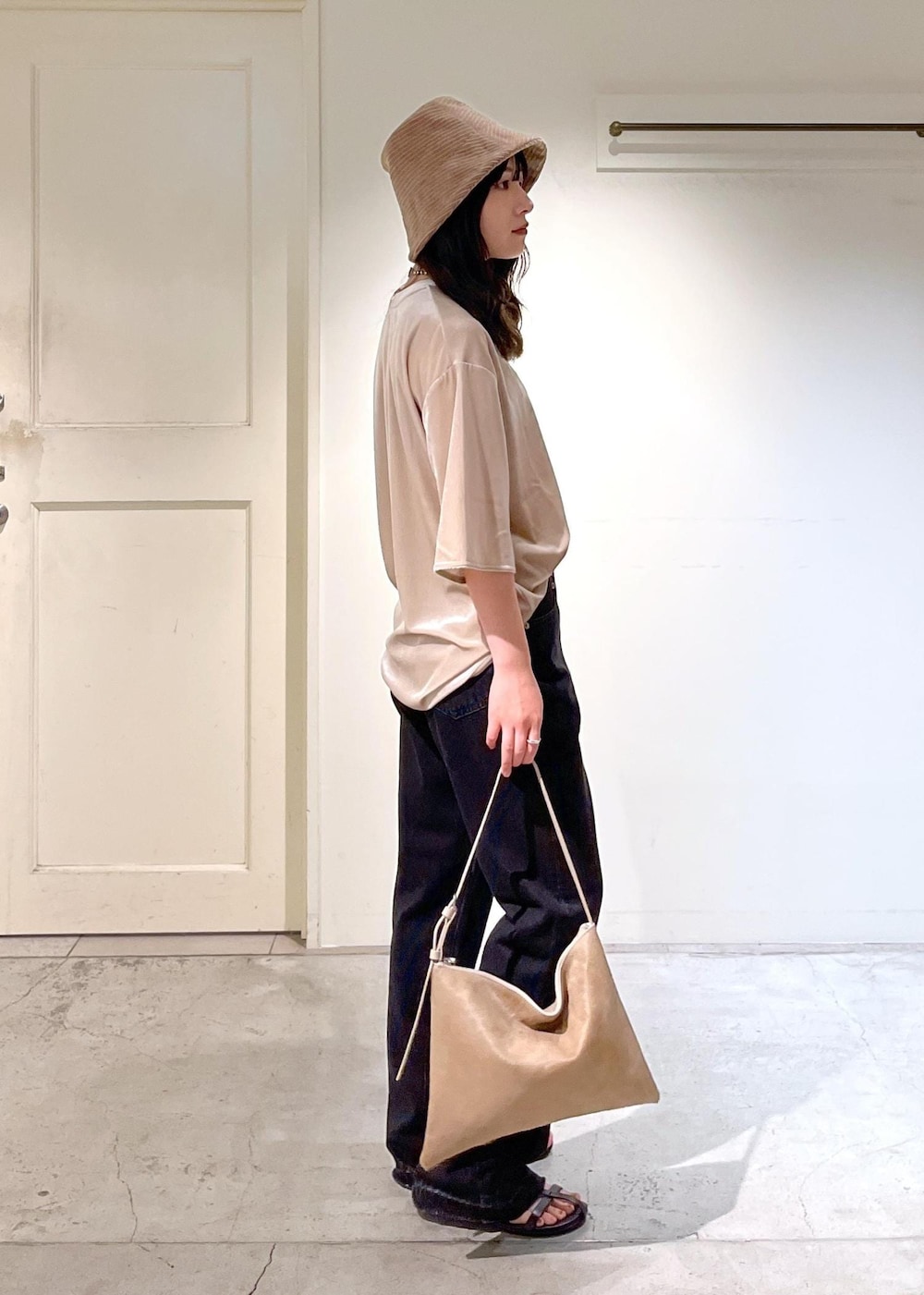 ブラック系のサンダル、グレー系のデニムパンツ、ベージュ系のTシャツ/カットソーを着用したレディースの夏コーディネートの3枚目の写真