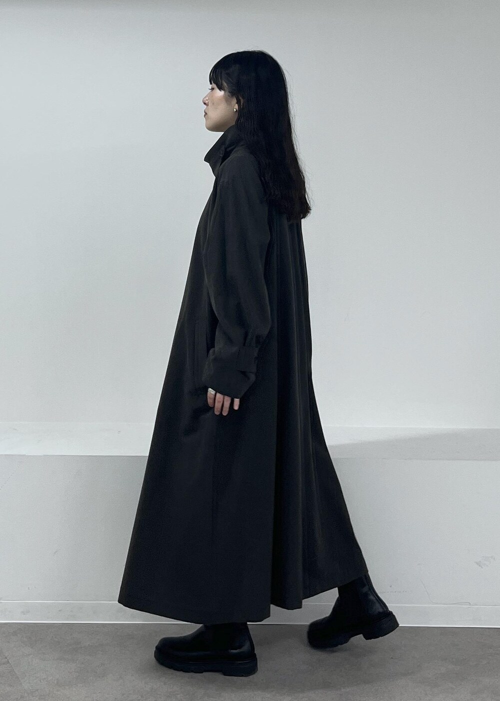 ブルー系のニット/セーター、グレー系のステンカラーコート、グレー系のその他パンツを着用したレディースの冬コーディネートの5枚目の写真