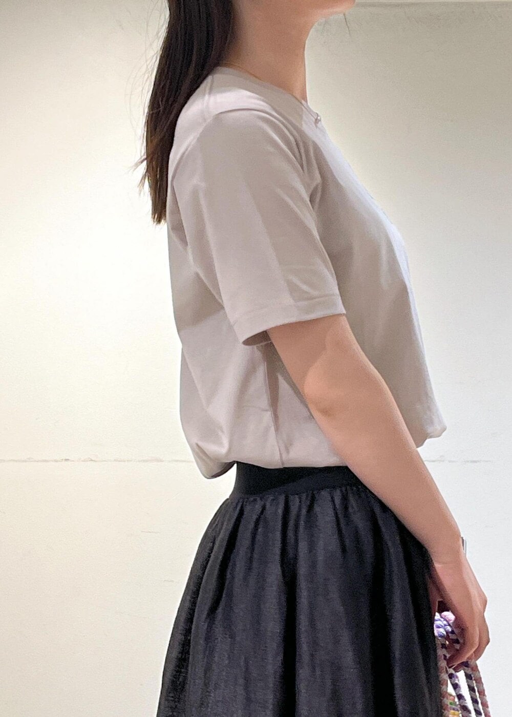 ブラック系のスカート、ベージュ系のTシャツ/カットソーを着用したレディースの夏コーディネートの6枚目の写真