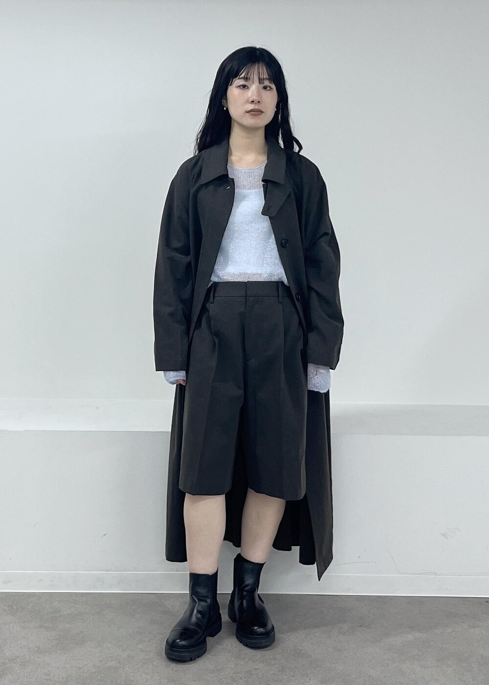 ブルー系のニット/セーター、グレー系のステンカラーコート、グレー系のその他パンツを着用したレディースの冬コーディネートの7枚目の写真