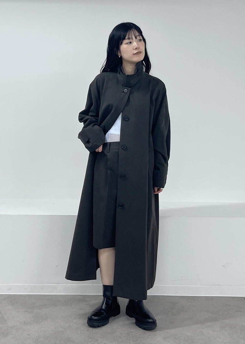 ブルー系のニット/セーター、グレー系のステンカラーコート、グレー系のその他パンツを着用したレディースの冬コーディネートの6枚目の写真