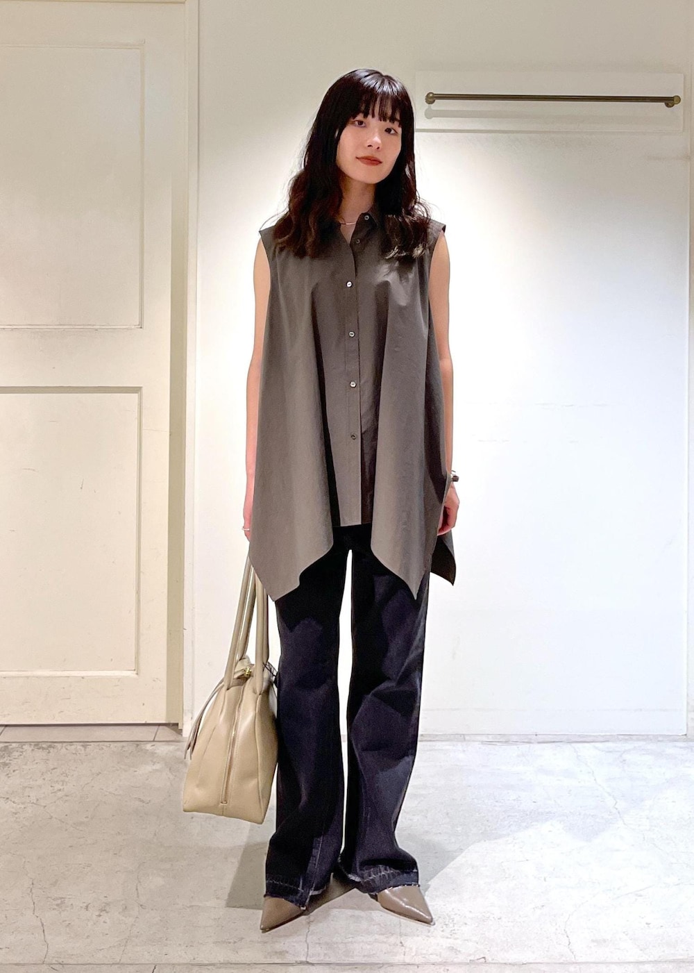 ベージュ系のボストンバッグ、グレー系のデニムパンツ、グレー系のシャツ/ブラウスを着用したレディースの夏コーディネートの2枚目の写真