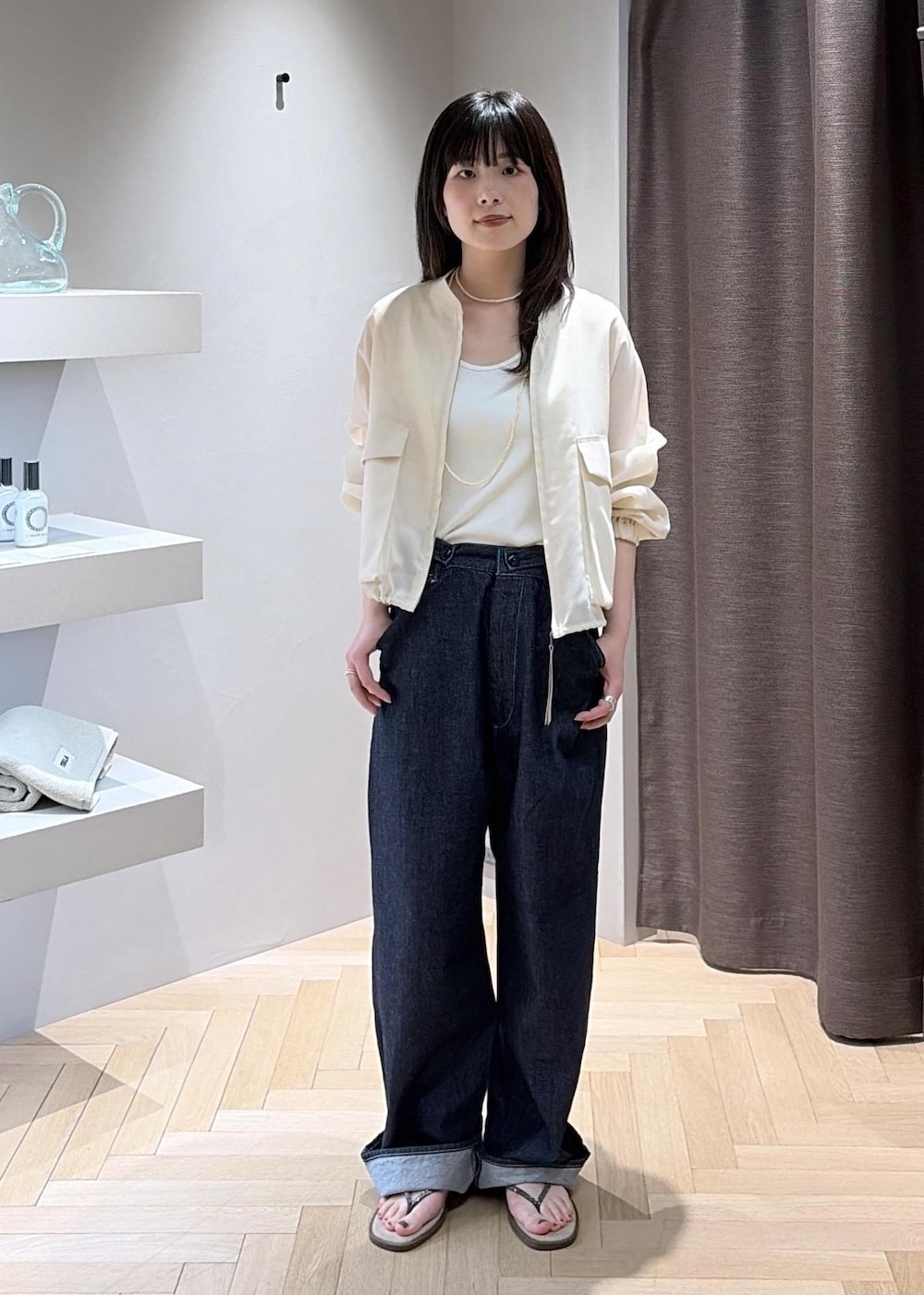 ベージュ系のサンダル、ブラウン系のハンドバッグ、ブルー系のデニムパンツを着用したレディースの夏コーディネートの6枚目の写真