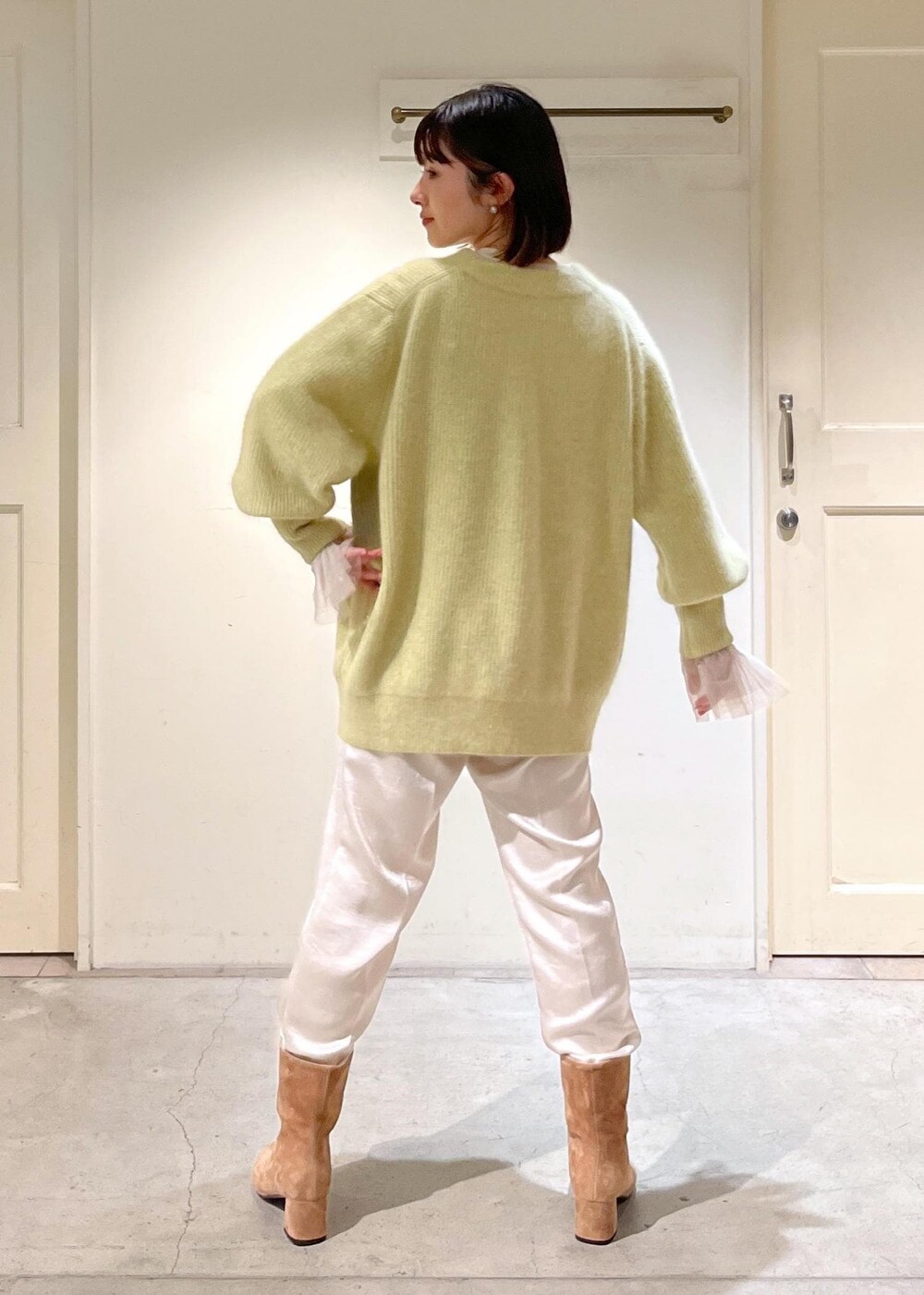 イエロー系のカーディガン/ボレロ、ブラウン系のブーツ、ホワイト系のその他パンツを着用したレディースの秋コーディネートの5枚目の写真