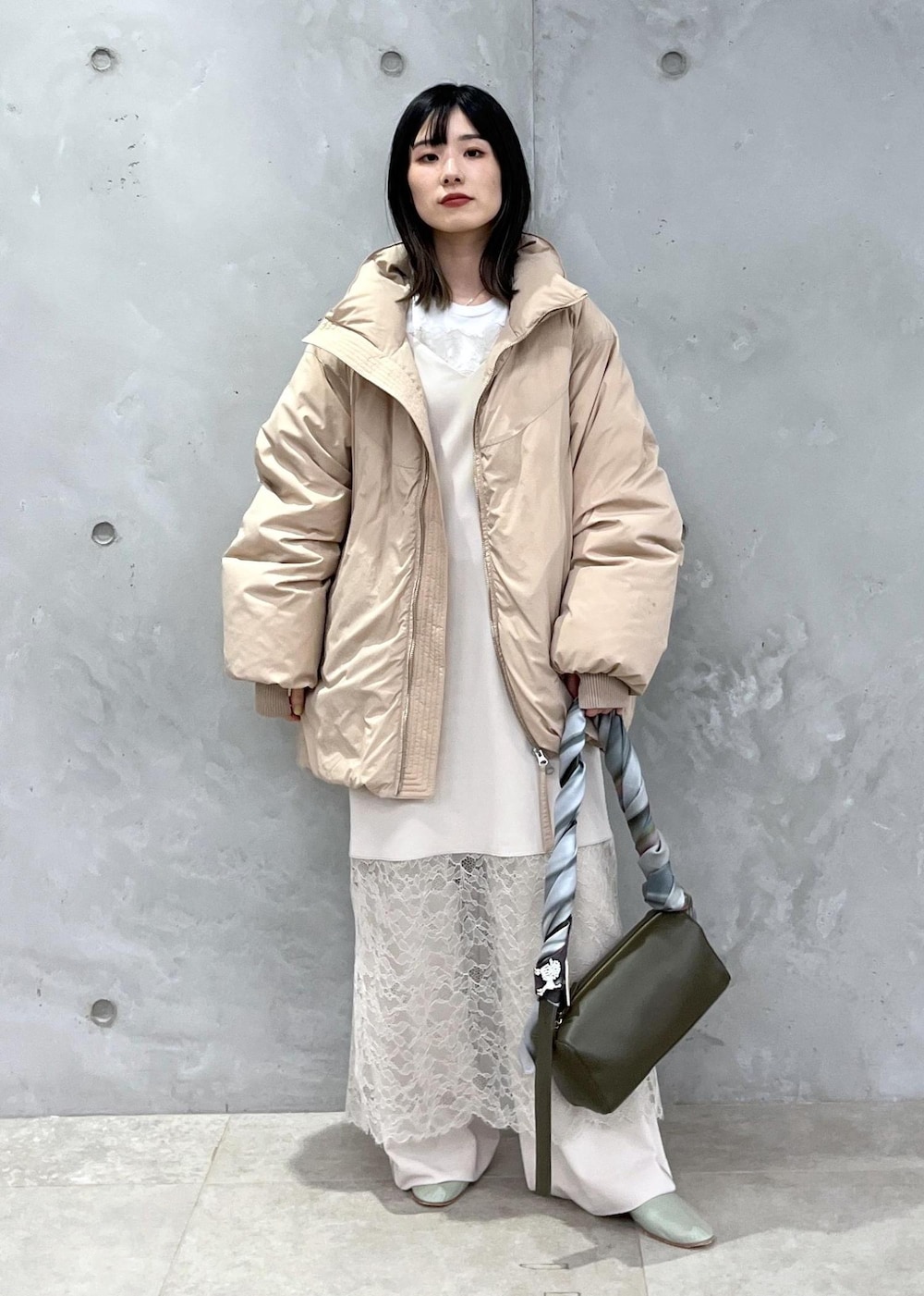 ベージュ系のダウンジャケット/コート、ホワイト系のその他パンツ、ホワイト系のワンピースを着用したレディースの冬コーディネートの3枚目の写真