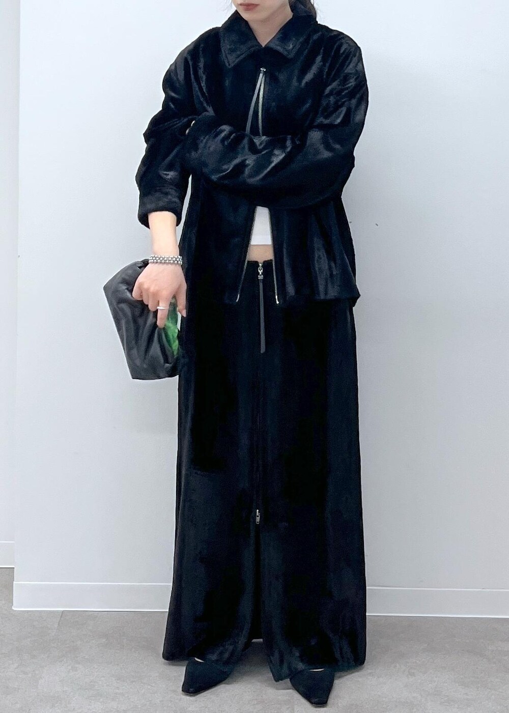 ブラック系のスカート、ブラック系のブルゾン、ブラック系のサンダルを着用したレディースの秋コーディネートの6枚目の写真