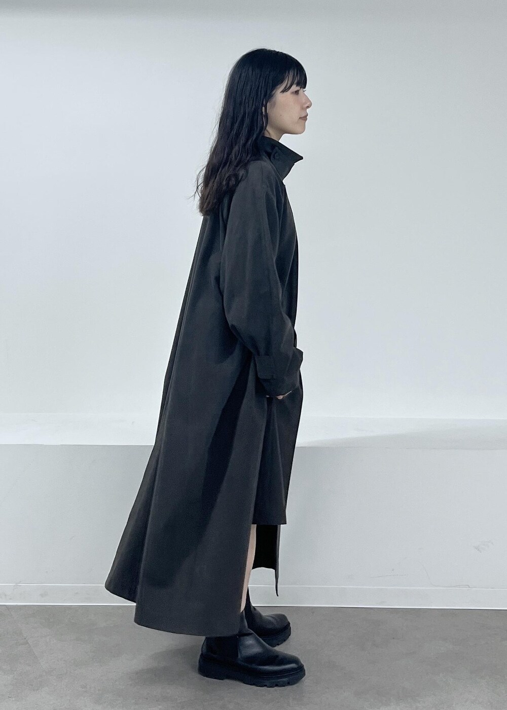 ブルー系のニット/セーター、グレー系のステンカラーコート、グレー系のその他パンツを着用したレディースの冬コーディネートの3枚目の写真