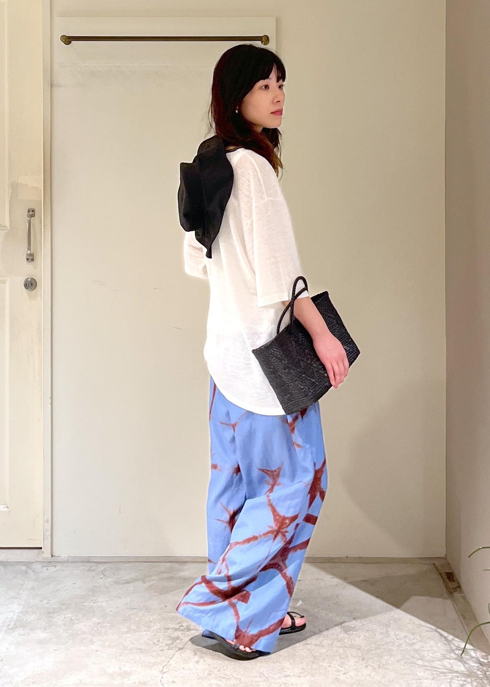 ブラック系のかごバッグ、ブラック系のサンダル、ブルー系のその他パンツを着用したレディースの春コーディネートの5枚目の写真