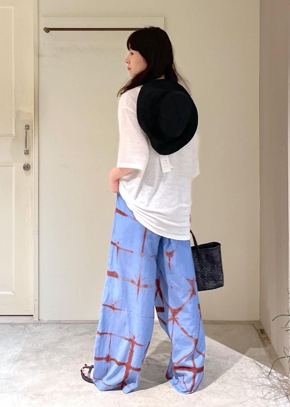 ブラック系のかごバッグ、ブラック系のサンダル、ブルー系のその他パンツを着用したレディースの春コーディネートの6枚目の写真