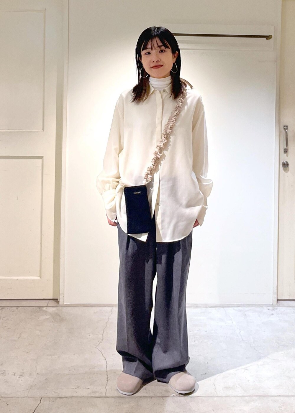 グレー系のサンダル、ホワイト系のシャツ/ブラウス、ホワイト系のTシャツ/カットソーを着用したレディースの冬コーディネートの3枚目の写真