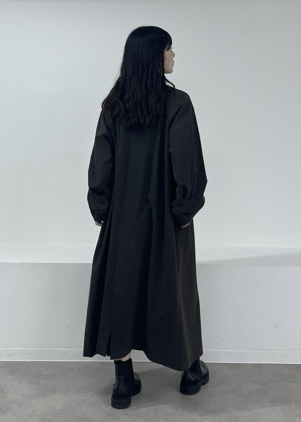 ブルー系のニット/セーター、グレー系のステンカラーコート、グレー系のその他パンツを着用したレディースの冬コーディネートの4枚目の写真