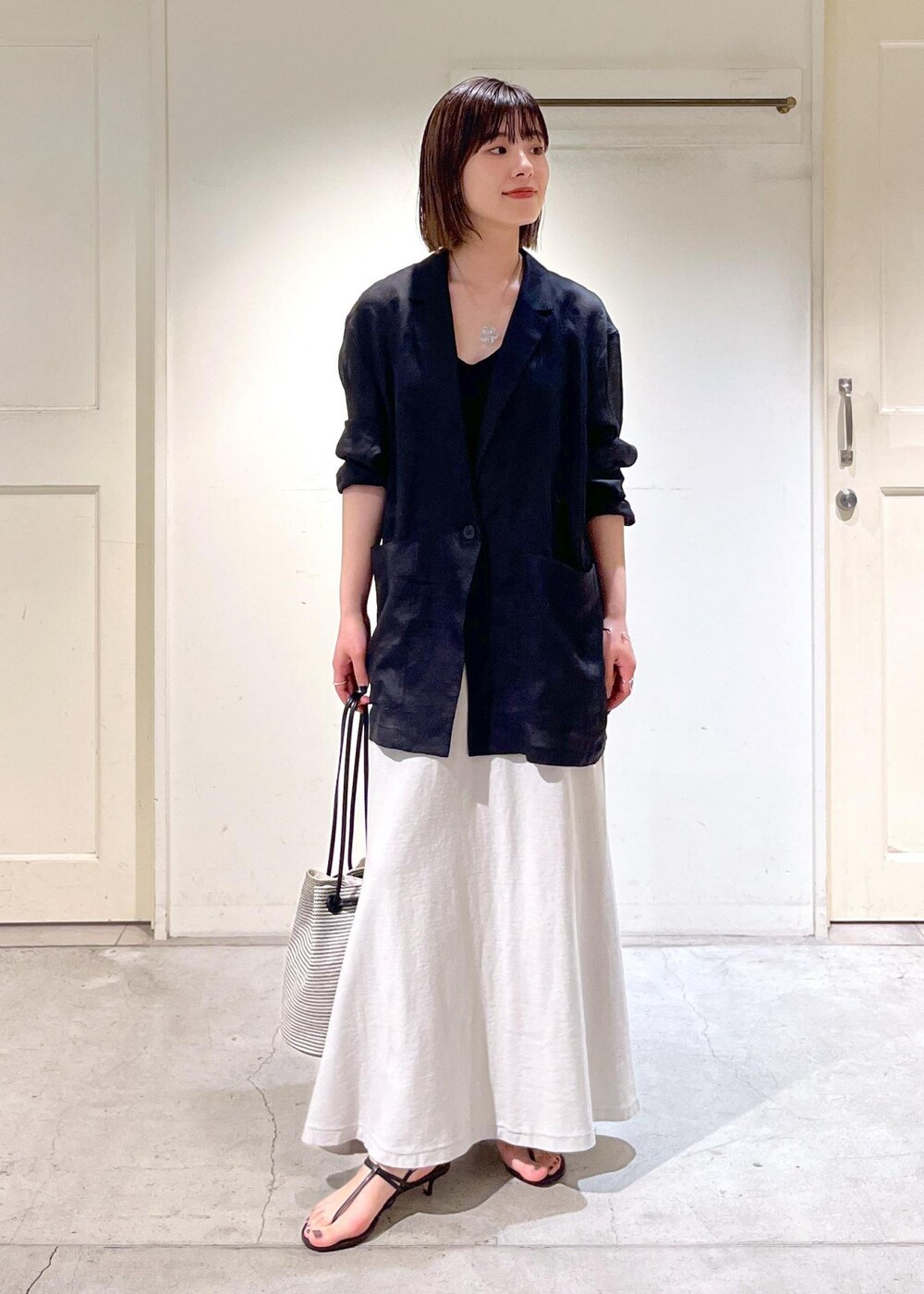 ブラック系のキャミソール、ブラック系のサンダル、ブラック系のショルダーバッグを着用したレディースの春コーディネートの5枚目の写真