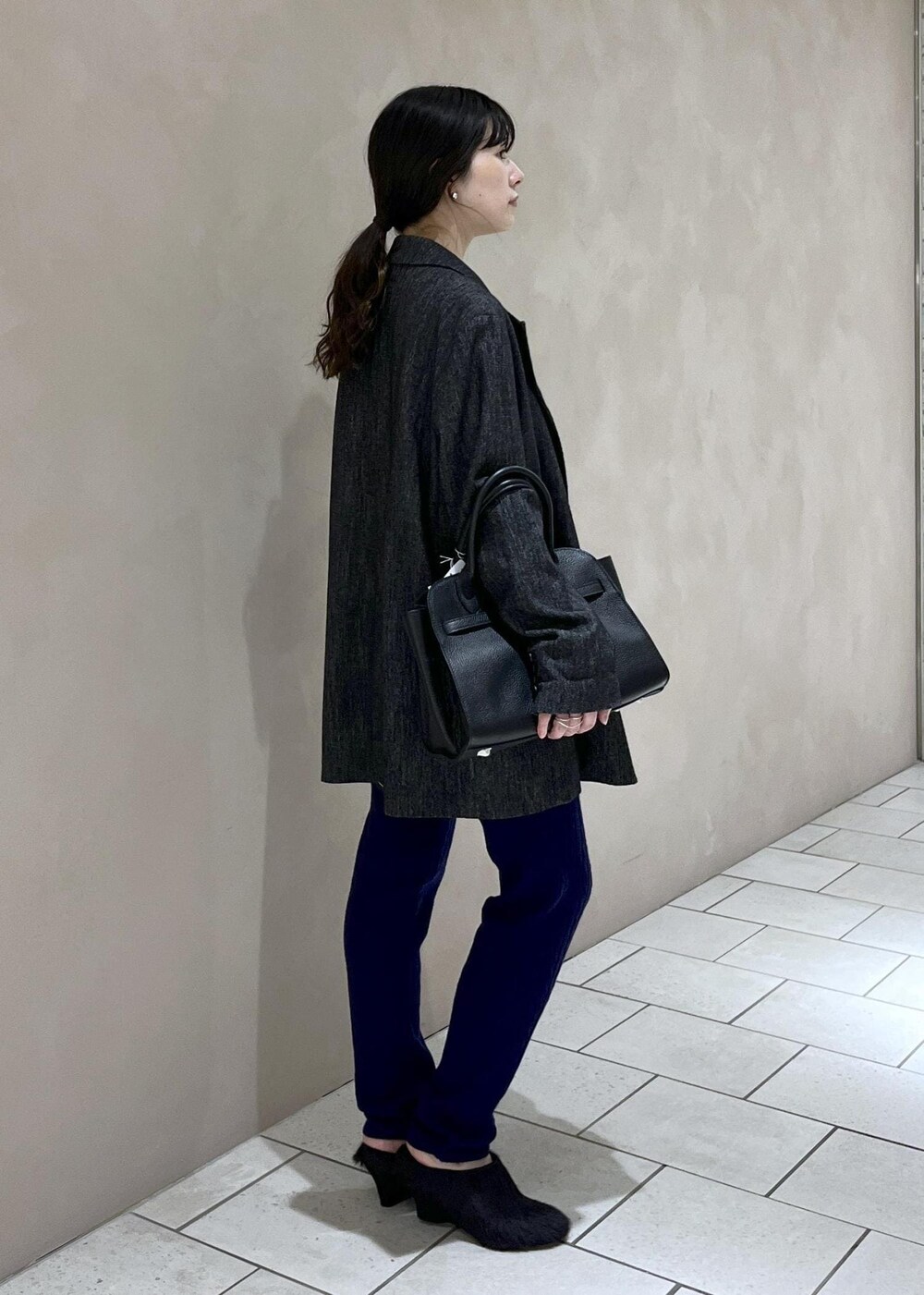 ブラック系のテーラードジャケット、ブラック系のハンドバッグ、ブラック系のその他シューズを着用したレディースの秋コーディネートの3枚目の写真