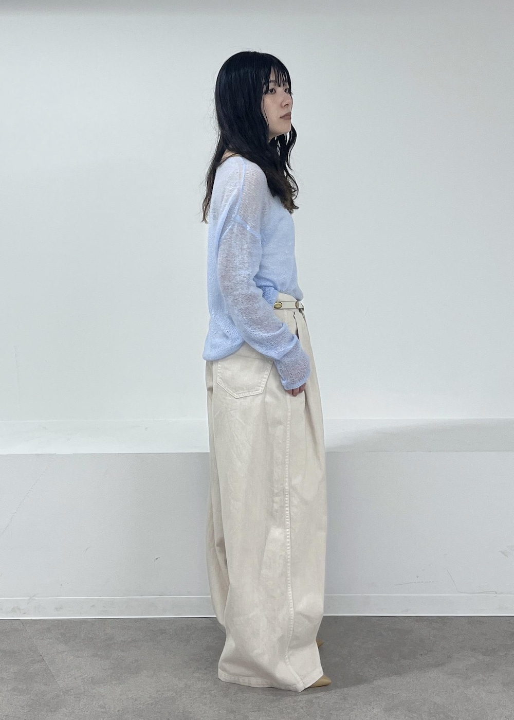 ホワイト系のデニムパンツ、ブルー系のニット/セーター、ベージュ系のパンプスを着用したレディースの冬コーディネートの4枚目の写真