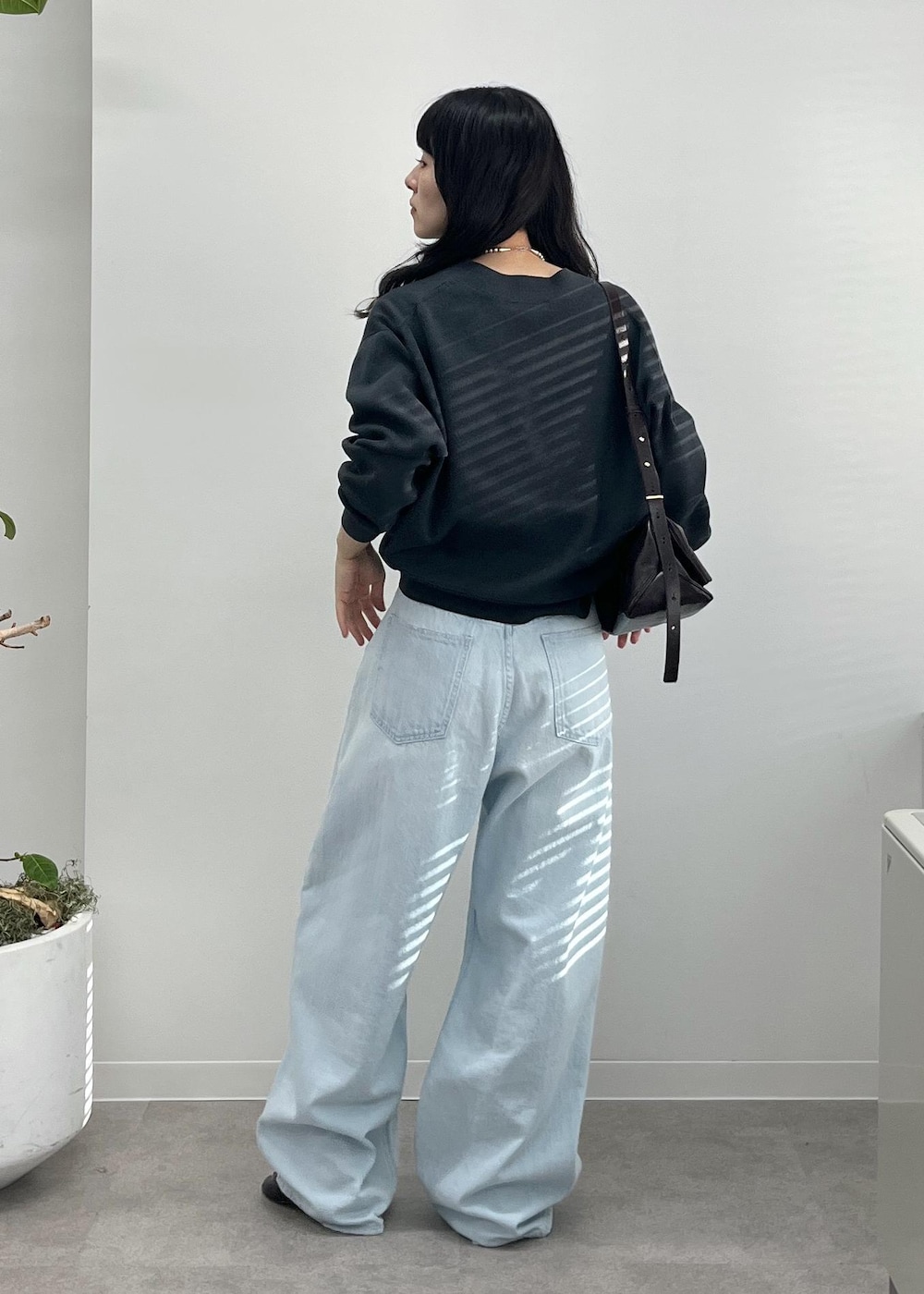 ブルー系のデニムパンツ、グレー系のカーディガン/ボレロ、ブラック系のショルダーバッグを着用したレディースの夏コーディネートの3枚目の写真