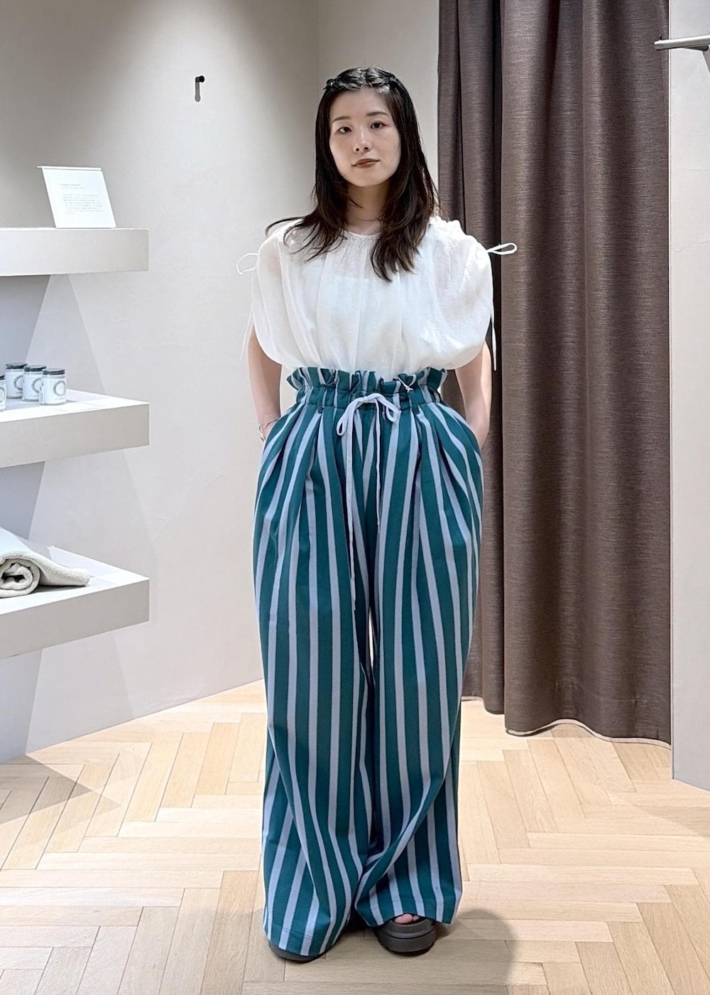 ホワイト系のシャツ/ブラウス、ホワイト系のショルダーバッグ、ブラウン系のサンダルを着用したレディースの春コーディネートの6枚目の写真