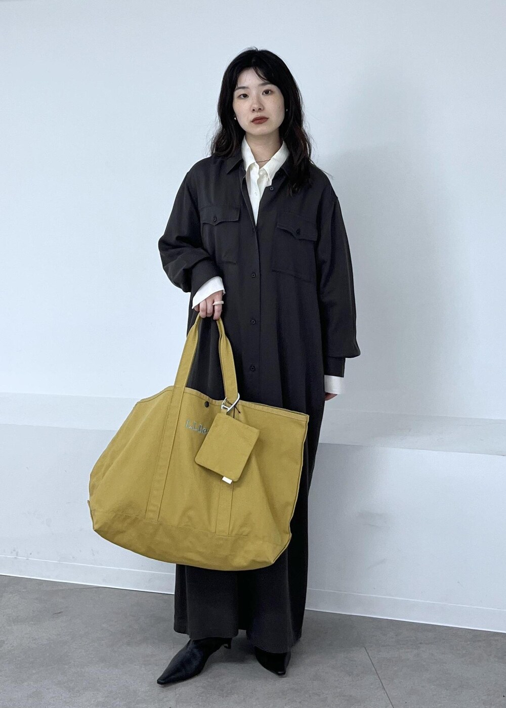 ホワイト系のシャツ/ブラウス、グレー系のワンピース、ブラック系のブーツを着用したレディースの秋コーディネートの6枚目の写真