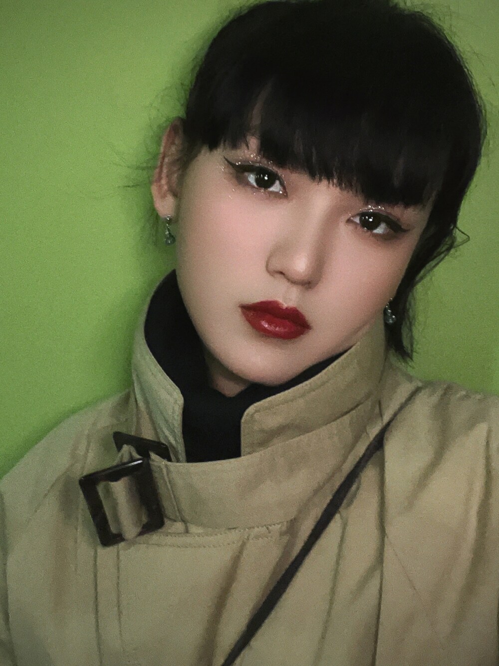 パープル系のパンツ、ブラック系のスニーカー、ベージュ系のトレンチコートを着用したレディースの春コーディネートの3枚目の写真