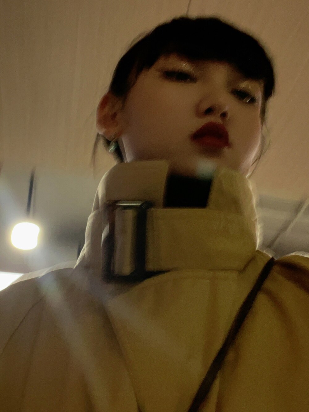 パープル系のパンツ、ブラック系のスニーカー、ベージュ系のトレンチコートを着用したレディースの春コーディネートの5枚目の写真