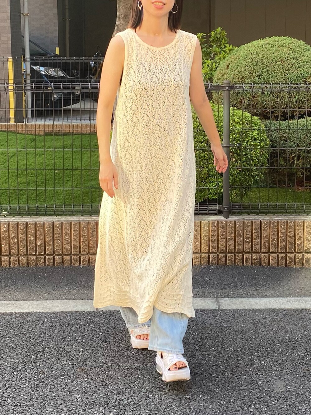 ホワイト系のサンダル、ブルー系のデニムパンツ、ブラック系のキャミソールを着用したレディースの秋コーディネートの3枚目の写真