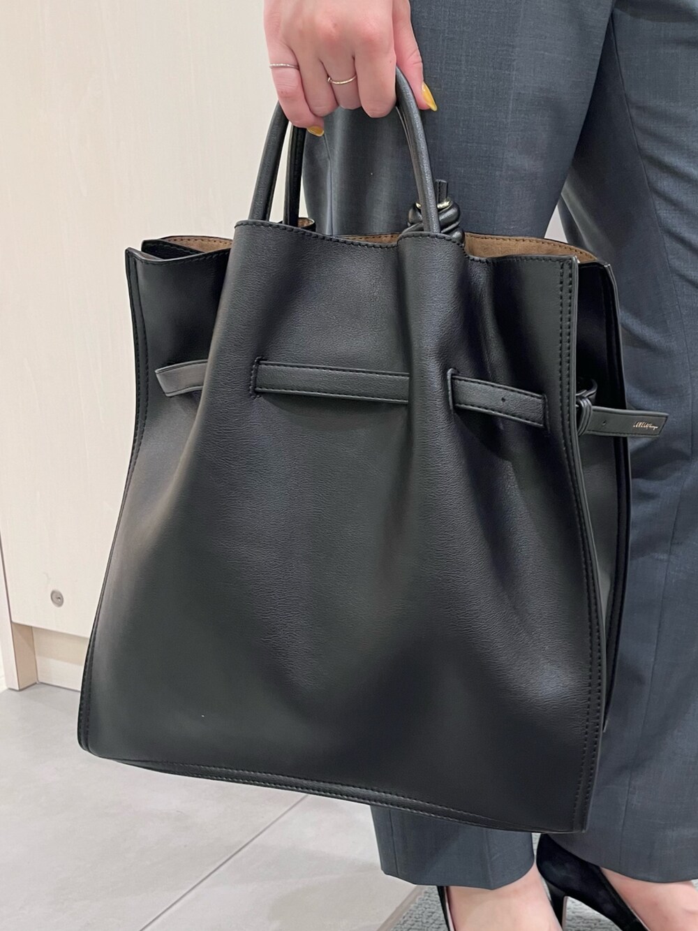 シルバー系のニット/セーター、グリーン系のスラックス、ブラック系のトートバッグを着用したレディースの夏コーディネートの7枚目の写真